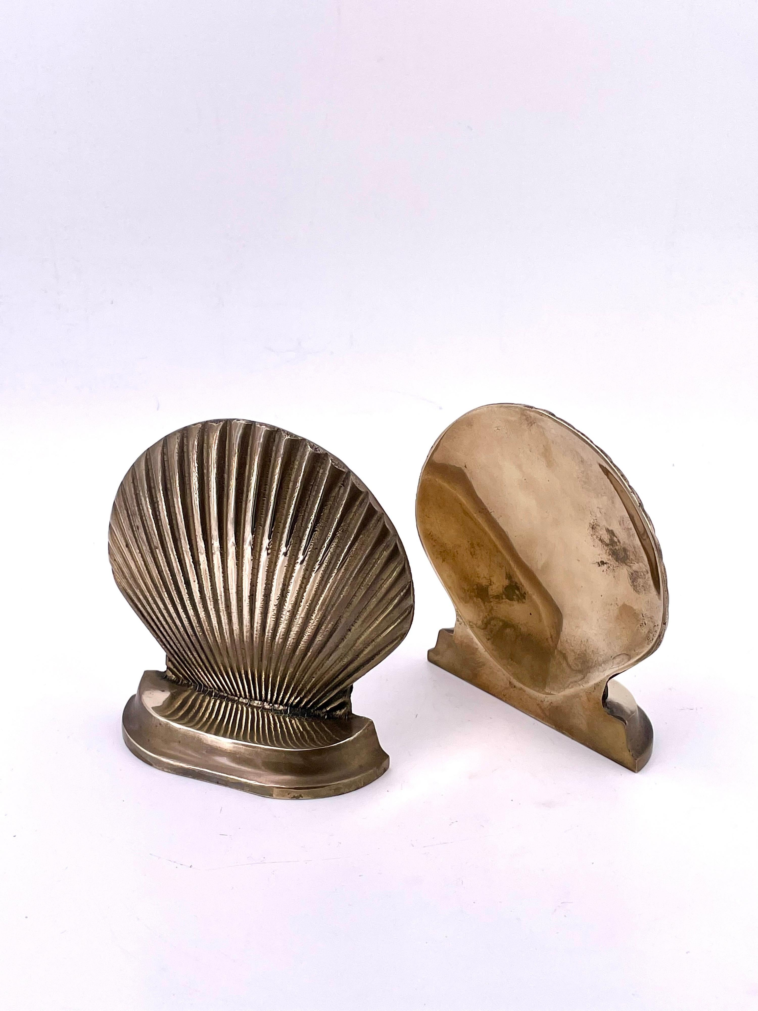 Incredibly glamourous polished brass seashell sculpture bookends. This pair stands alone as sculptural objects that amplify your style or become an evident piece of uniqueness in your eclectic library décor. The brass has been lightly polished and