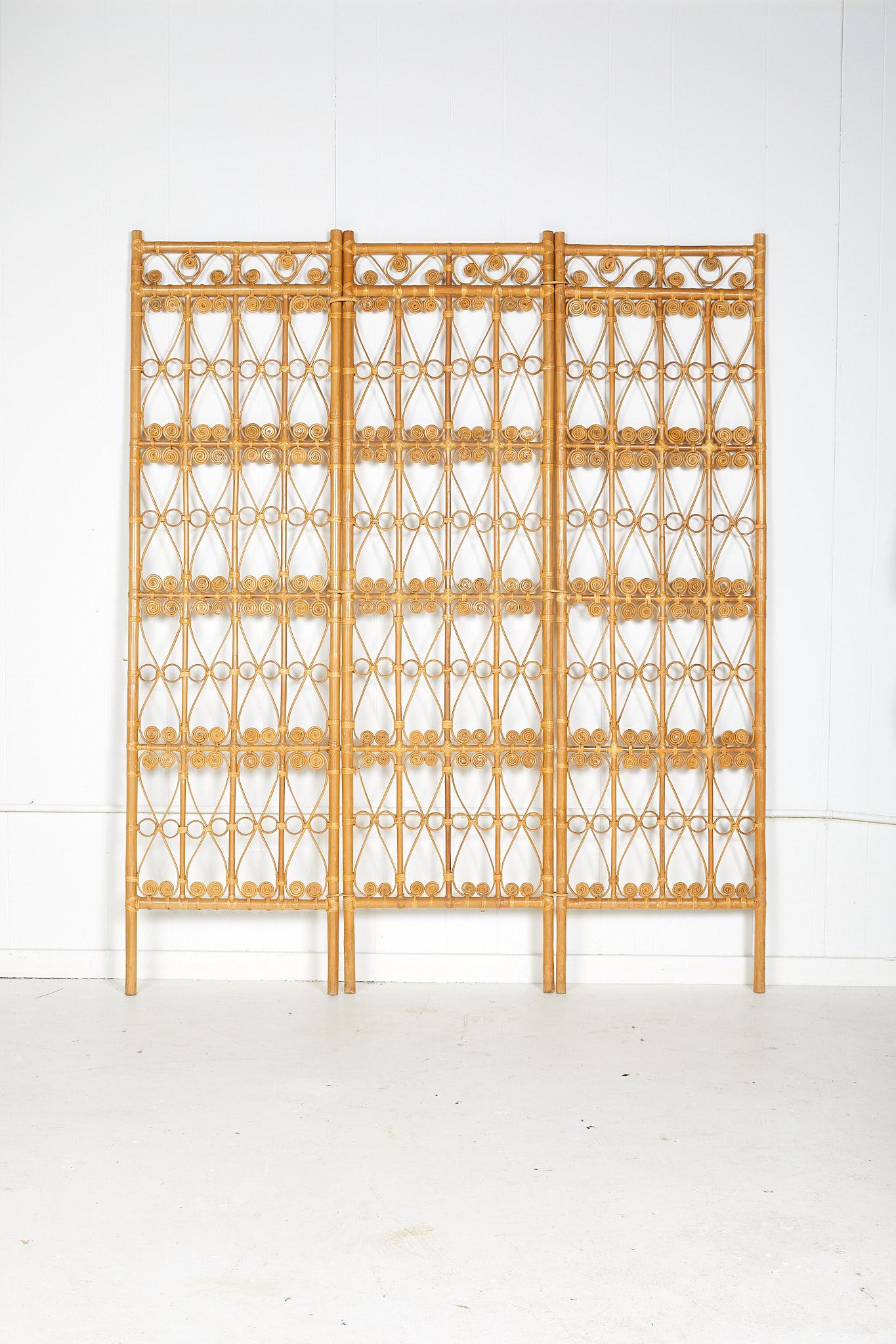 Vintage 1970s three panel folding screen or room divider made of rattan in the manner of Hollywood Regency.