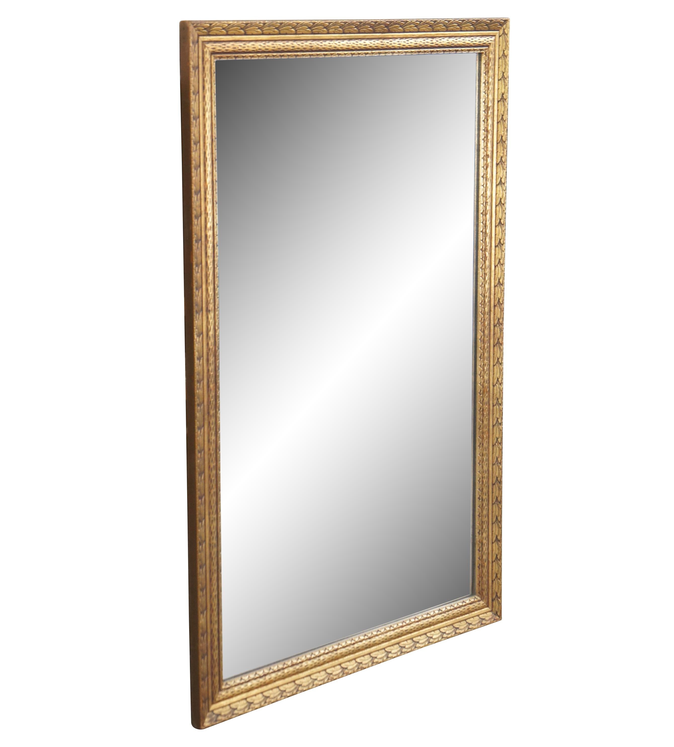 Vintage Hollywood Regency gold over mantel vanity mirror featuring rectangular form with carved accents.


