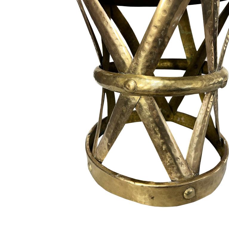 A vintage Mid-Century Modern or Hollywood Regency brass hand-hammered stool. This piece could be used as either additional seating or as a side or drinks table! The piece is round and constructed of brass. The top is a solid sheet of brass with