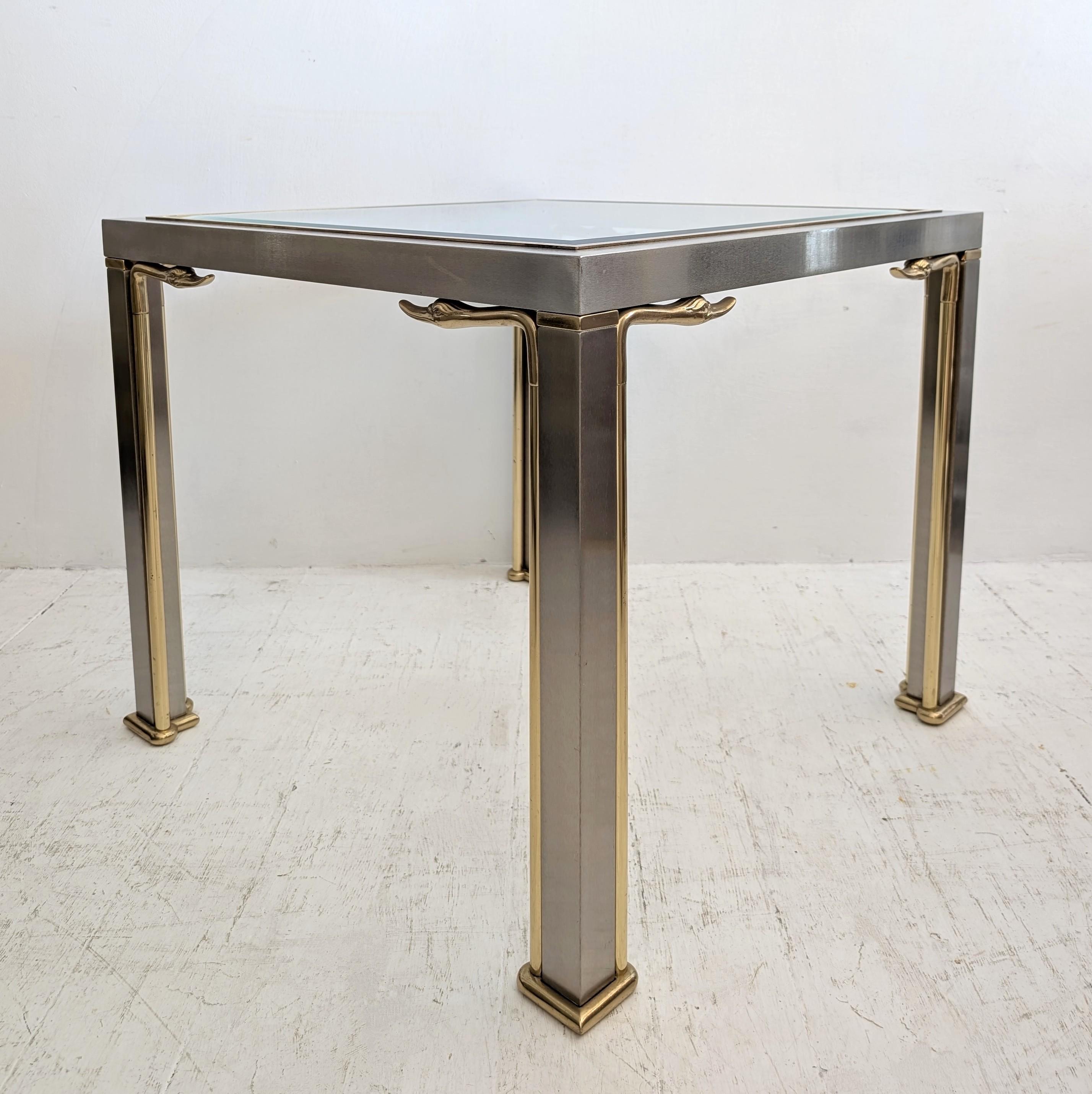 Mesa auxiliar o de centro vintage francesa Hollywood Regency de acero cepillado y latón con cabezas de cisne alargadas, EE.UU. Años 70. La parte superior es de cristal biselado.

En buen estado vintage: algunos rasguños en el acero y un pequeño