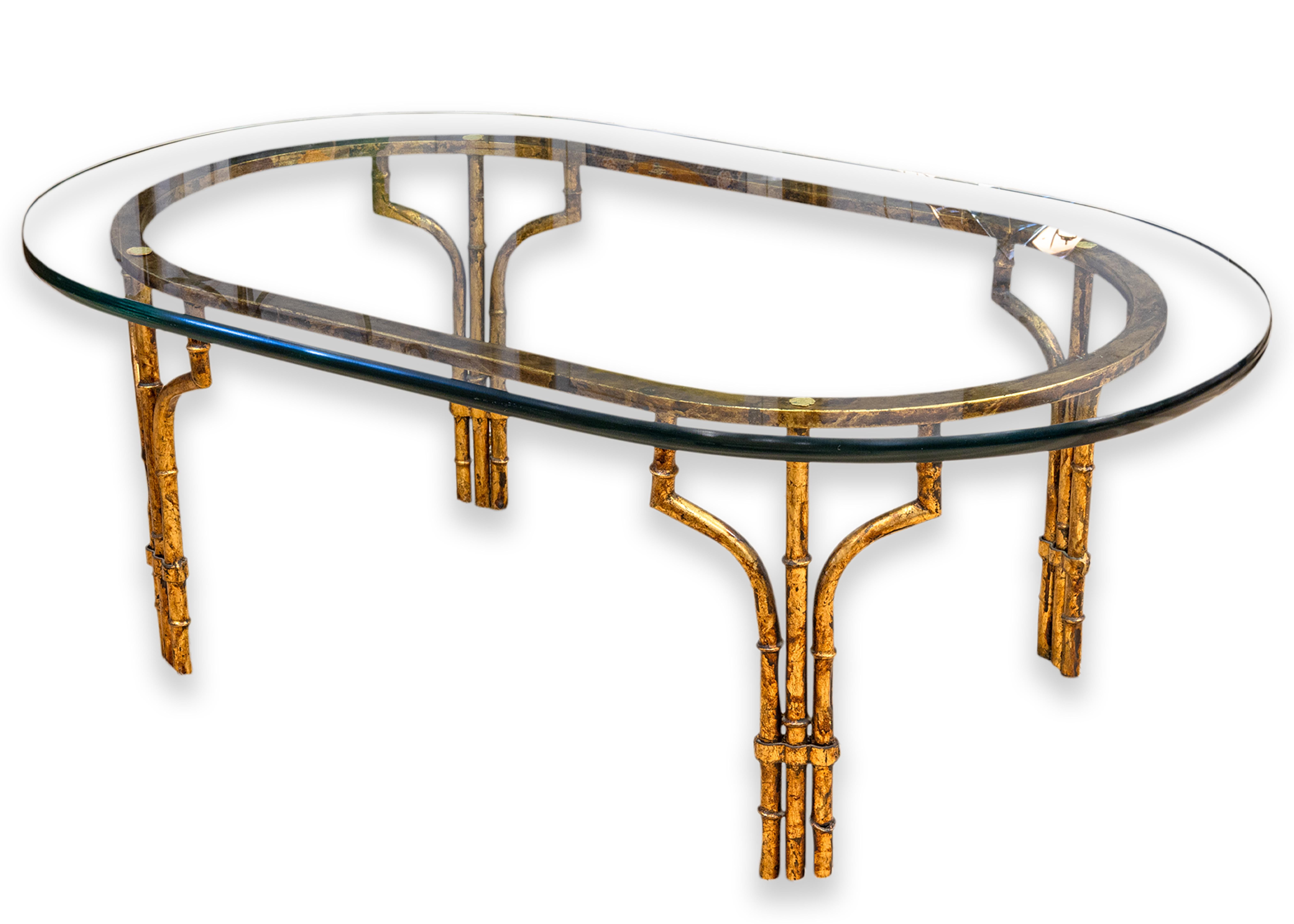 Table basse vintage de style Hollywood Regency. Cette magnifique table basse présente une finition glamour en faux laiton doré. Le cadre se présente sous la forme d'un bambou doré avec des attaches autour des pieds. Cette pièce présente un grand