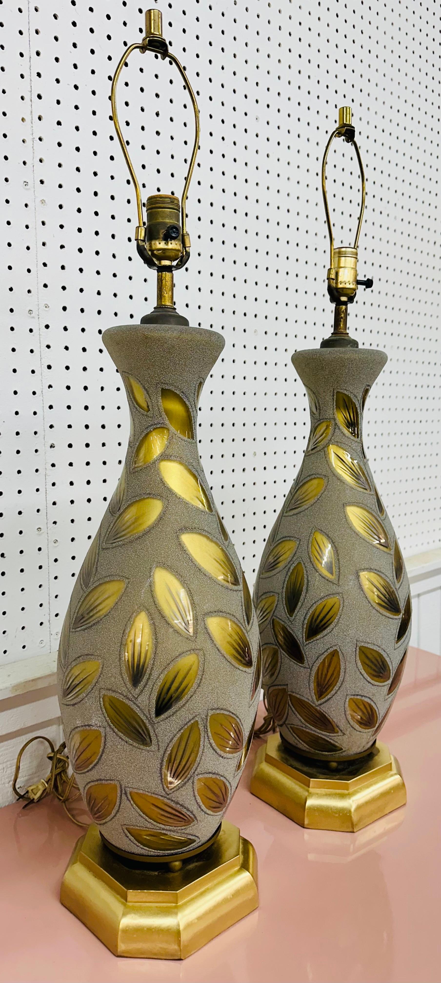 Diese Auflistung ist für ein Paar von Vintage Hollywood Regency Style Glas Tischlampen. Mit vasenförmigem Design, dekorativem Blattgoldglas, goldenem Sockel und originellen Messingharfen und -zierteilen. Dies ist eine außergewöhnliche Kombination