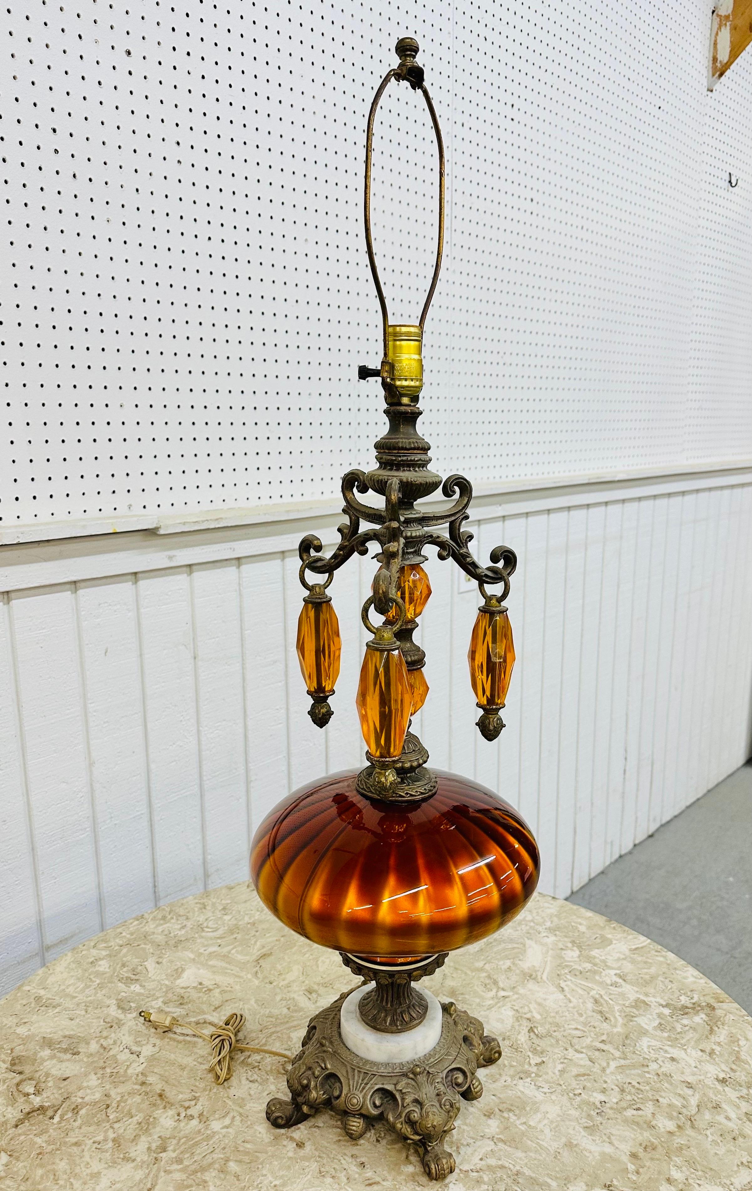 Cette annonce concerne une lampe de table en verre orange de style Hollywood Regency. Comprend une base en laiton et en marbre, un corps en verre orange, trois prismes en lucite suspendus, ainsi qu'une harpe et un cordon d'origine. Il s'agit d'une