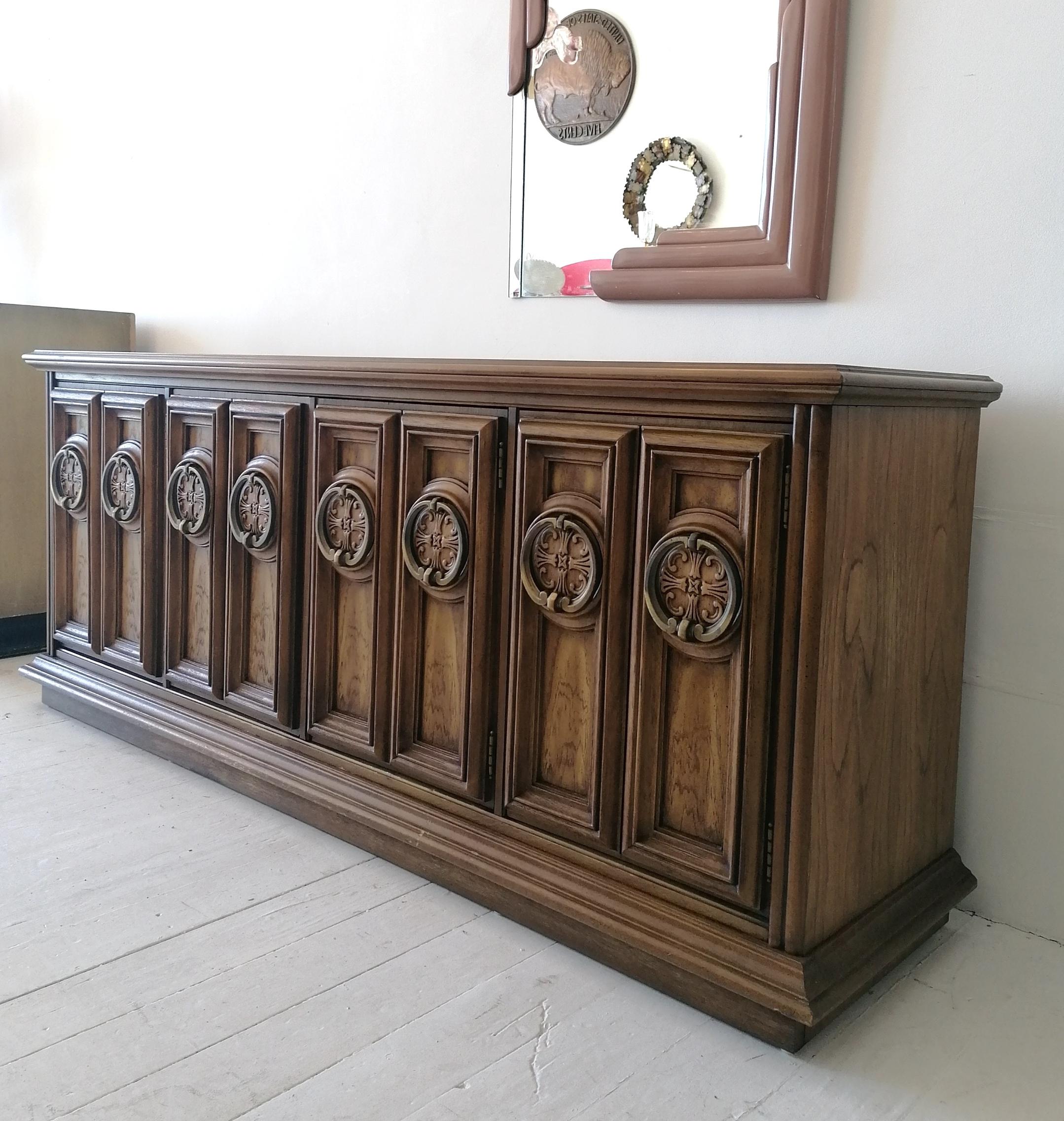This flamboyant Hollywood Regency walnut sideboard is by Stanley Furniture, USA, 1960s. The oversized brass ring door pulls are a great feature. Quite a neat, useable size, this one.
Inside are shelves & 1 central drawer.
In excellent condition.