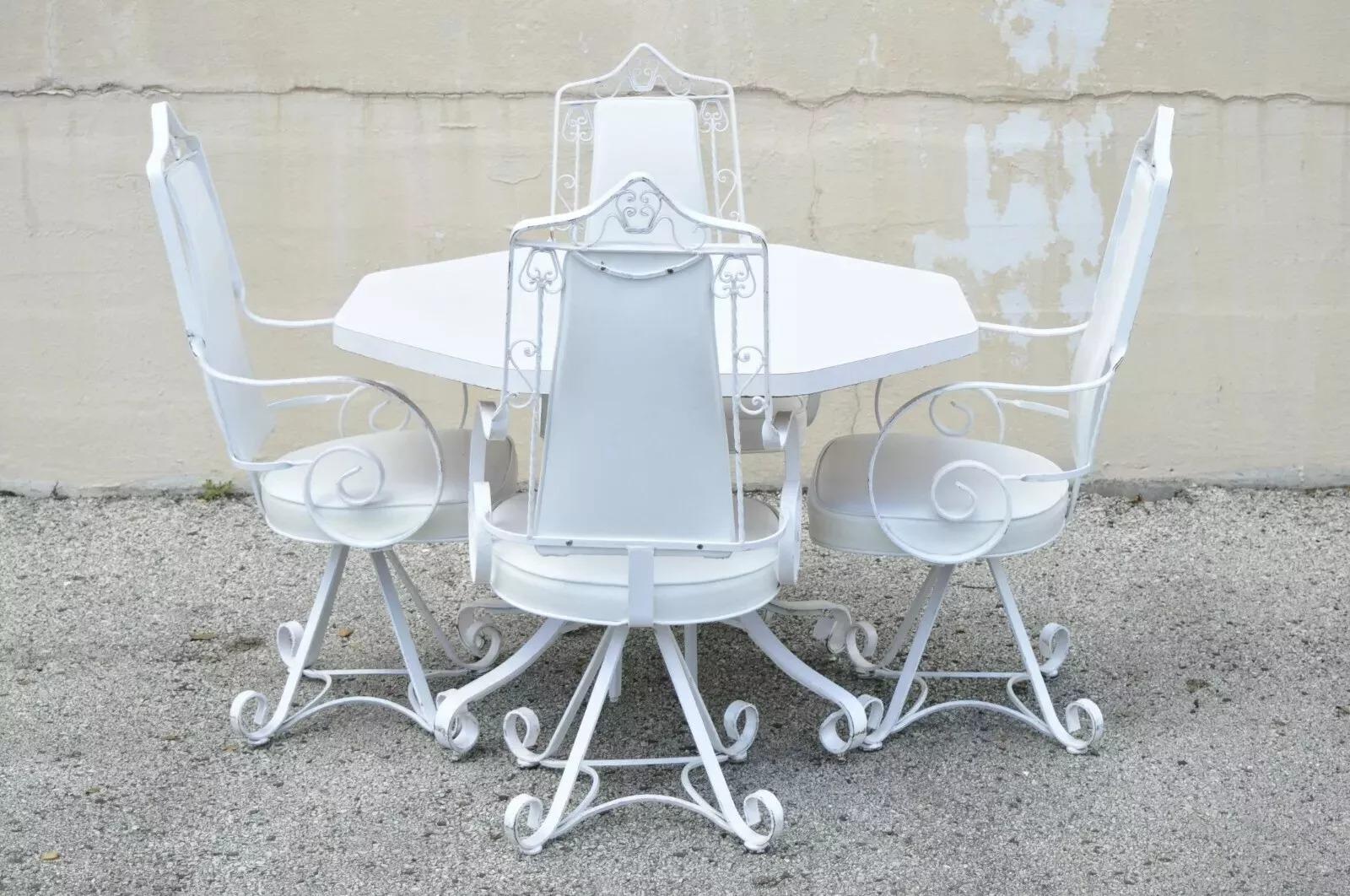 Vintage Hollywood Regency White Wrought Iron Scrolling Swivel Kitchen Dining Set - 5 pc Set. La liste comprend (4) chaises pivotantes à volutes, (1) table de salle à manger avec plateau octogonal en stratifié, design à volutes, revêtement en vinyle,