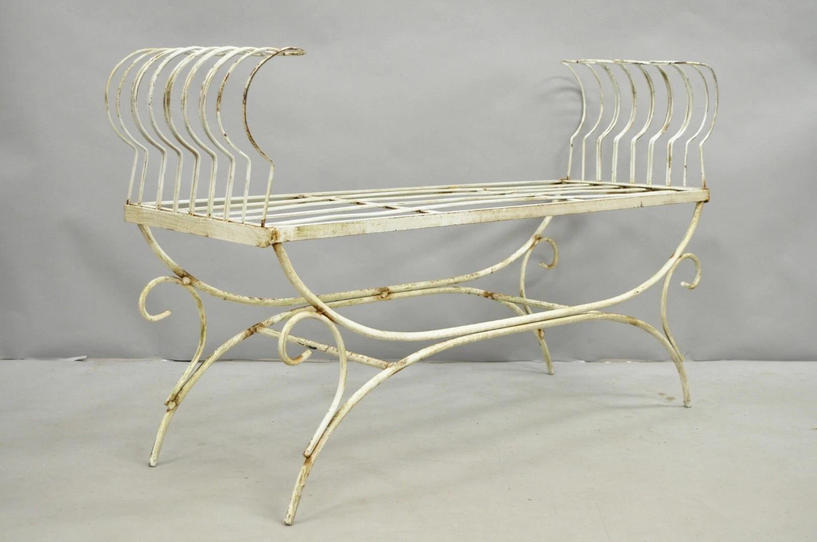 Please message us with your zip code to request a more reasonable domestic U.S. shipping quote.

Vintage Hollywood Regency White Wrought Iron Curule X Frame Window Bench with White Distress Painted Finish. Bench originally had long seat cushion and