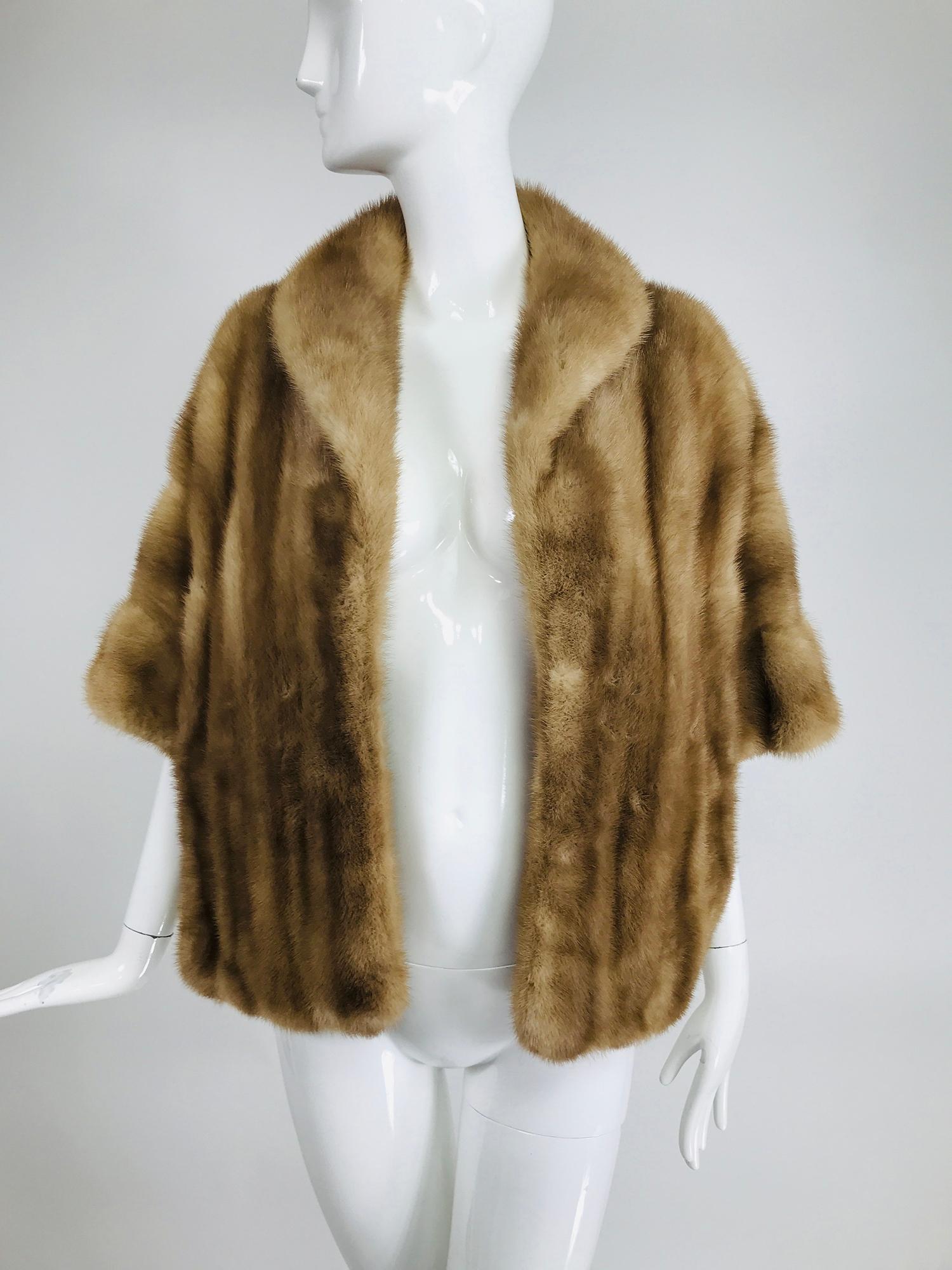Vintage honey blond mink stole with hidden sleeves from the 1960s. Beautiful cape in a warm honey blond wear as a cape or snaps inside create short interior sleeves for a different look. The cape has a gathered draped hem effect. A shawl collar and
