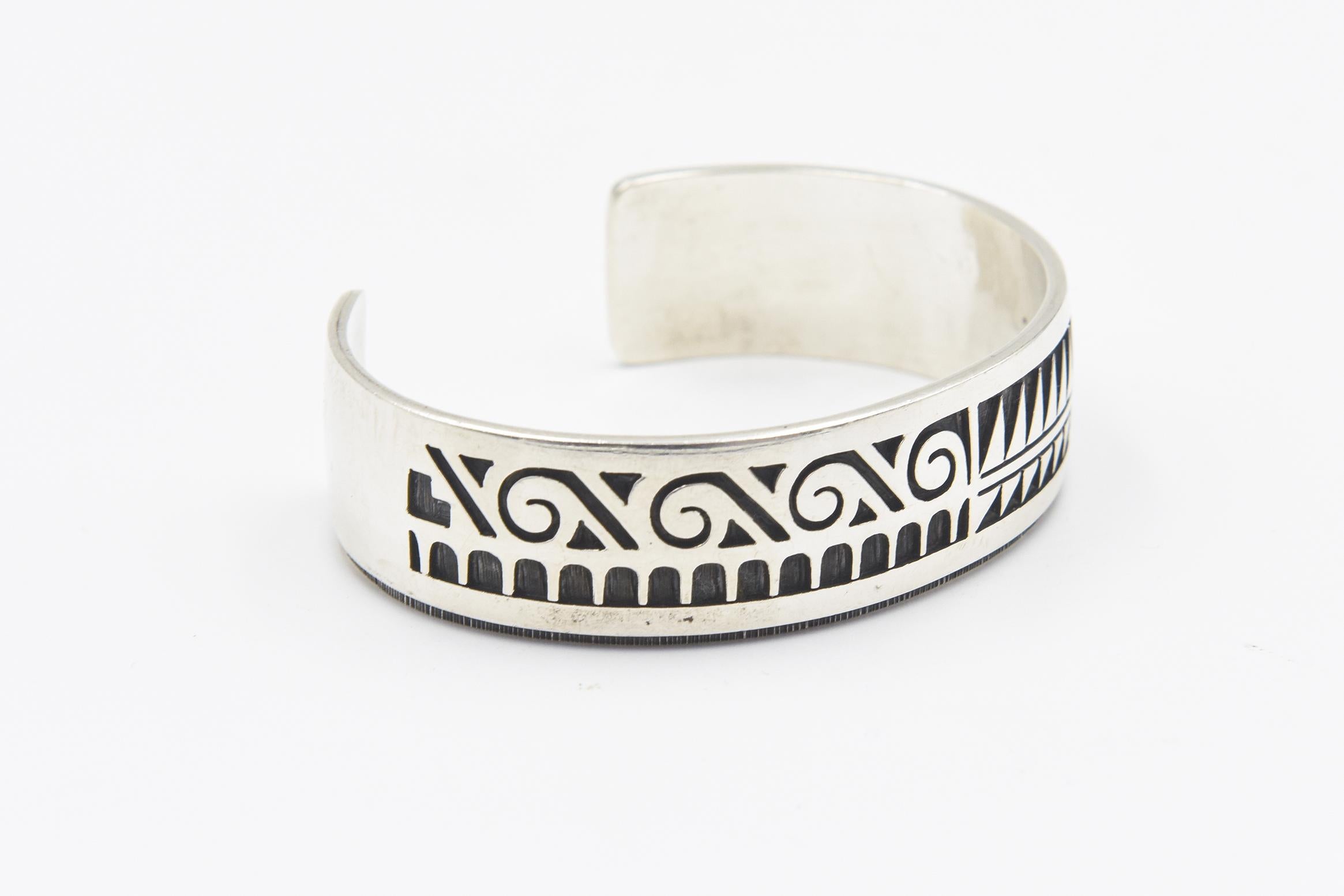 Sterling silver overlay cuff by Hopi silversmith Chalmers Day. The cuff features a pictorial overlay design. The inside is 5 3/4