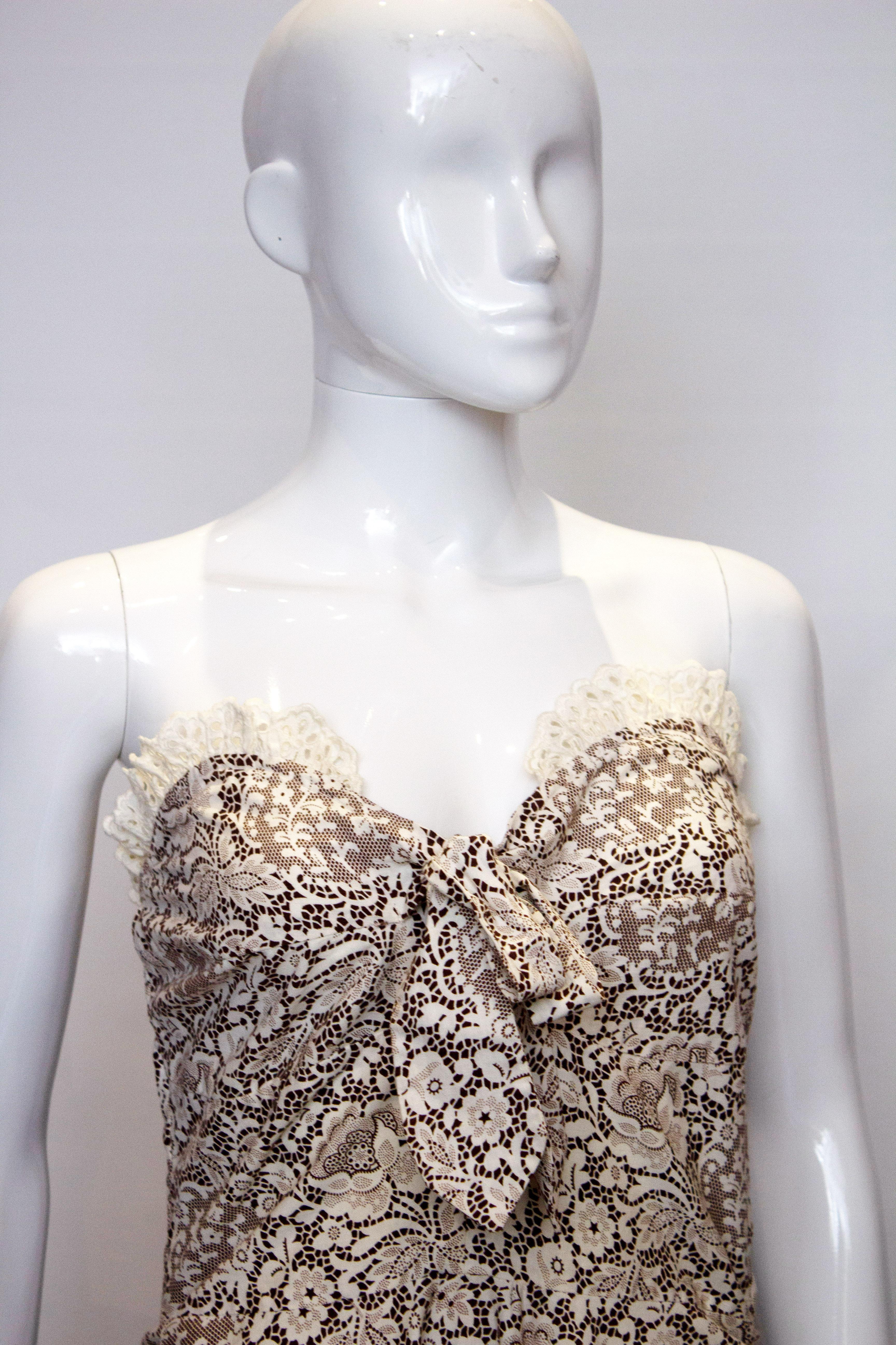 A fun vintage dress by Horrocks with a matching bolero. The dress is in  a brown and white print with a lace frill at the hem. The dress has a sweetheart neckline, boning in the bodice and a central back zip. The bolero has a shawl collar and