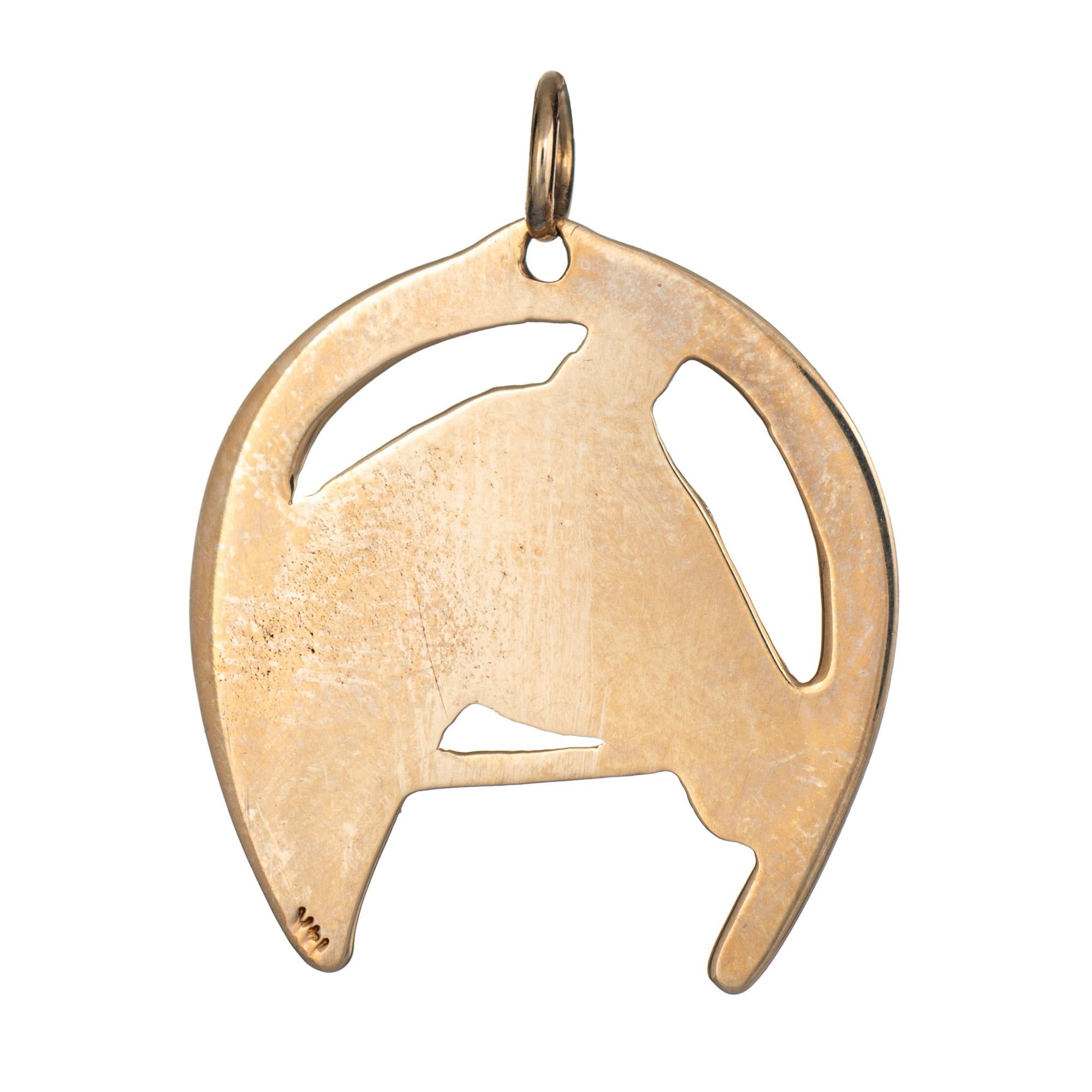 Finely detailed vintage equine themed horse pendant crafted in 14 karat yellow gold (circa 1960s to 1970s). 

The bust of a horse is framed with a good luck horseshoe. The nicely detailed piece can be worn as a pendant or charm on a bracelet.  