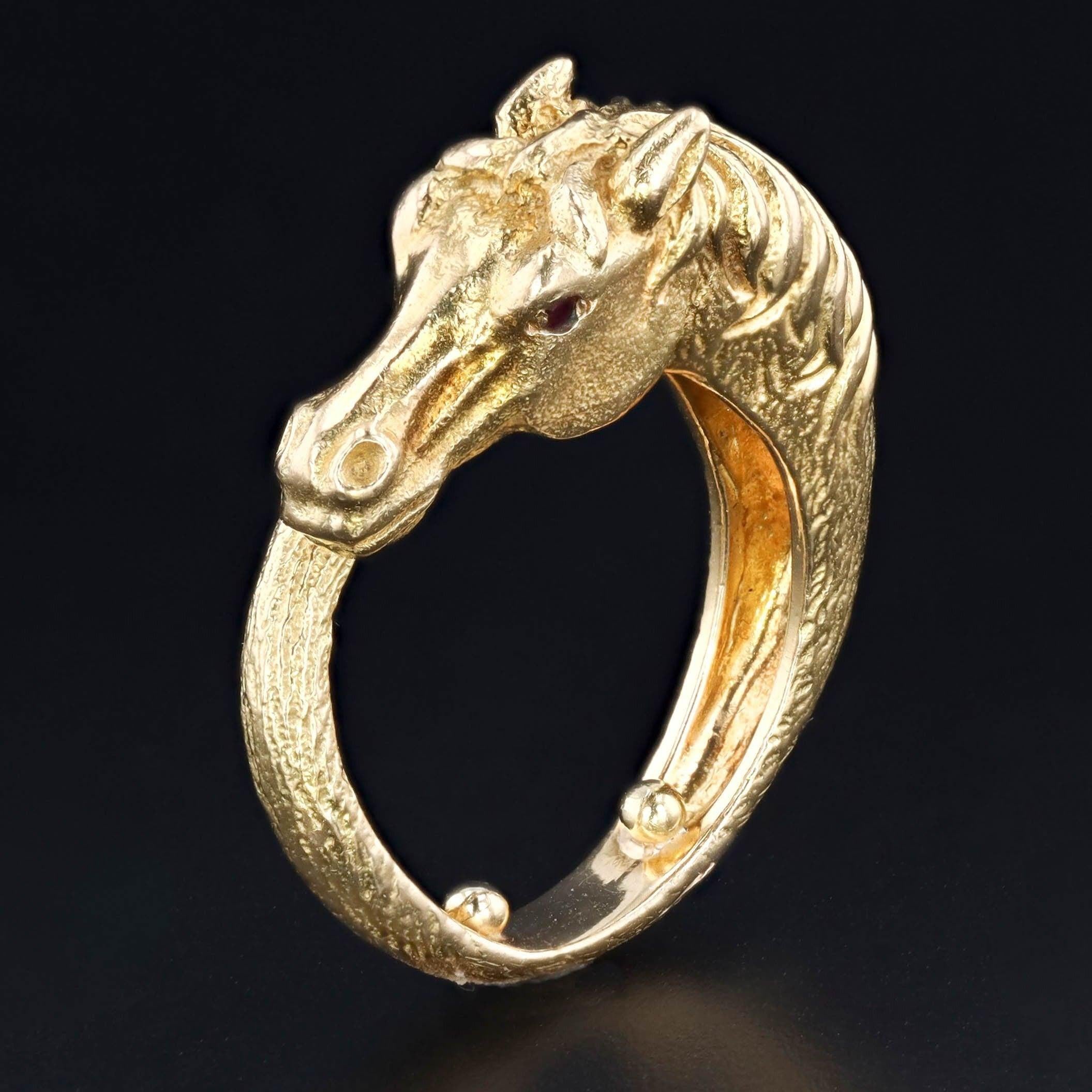 This golden horse ring is sure to gallop into any heart!

The finely rendered ring is 18k gold (unmarked, but acid tested) with ruby eyes. The horse wraps around the finger and has sizing beads that prevent it from spinning.

The ring is a size 5