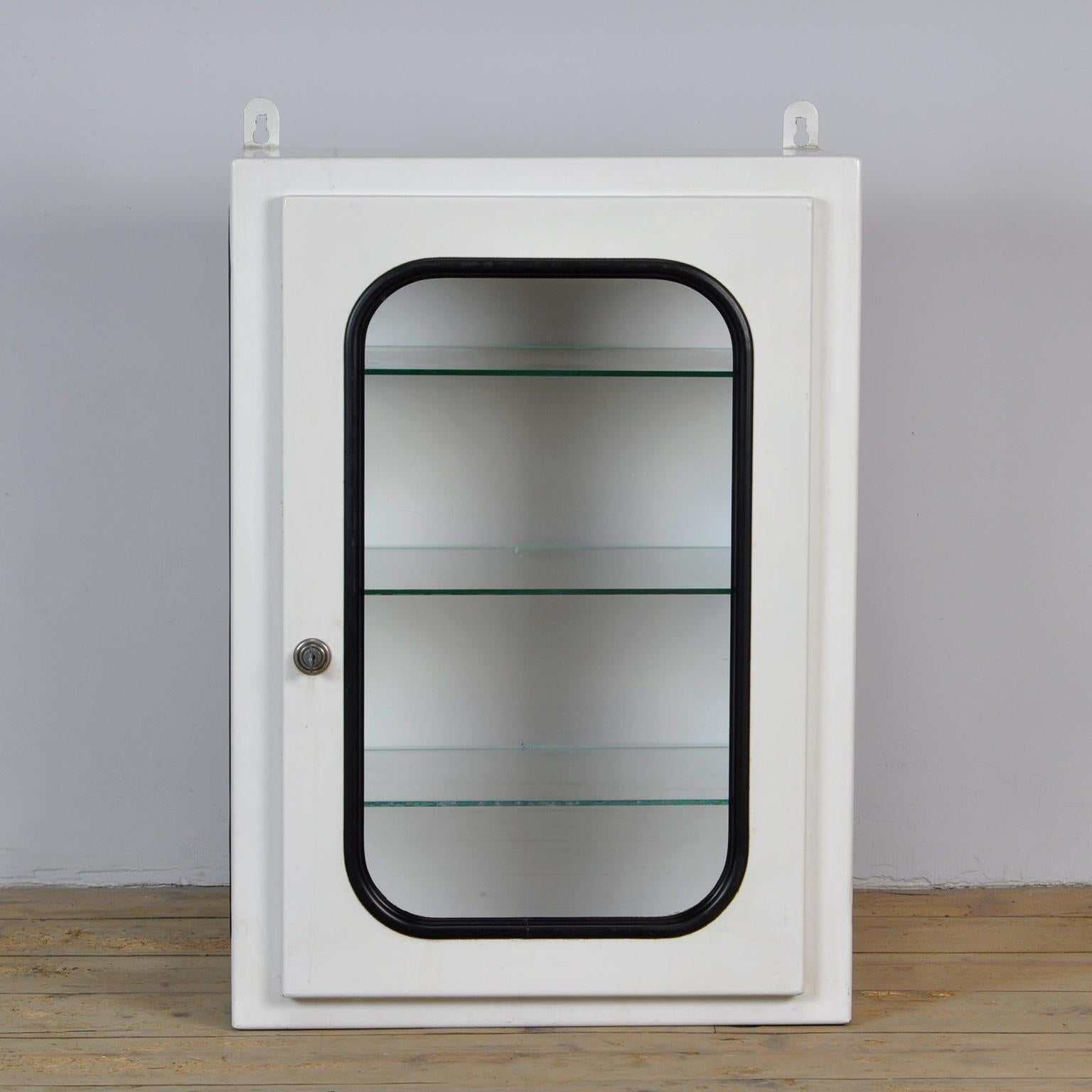 This medical cabinet was designed in the 1970s and produced circa 1975 in hungary. It was used in a hospital in Budapest. It is made of iron and glass. The glass is held by a black rubber strip. The cabinet comes with three adjustable glass shelves.