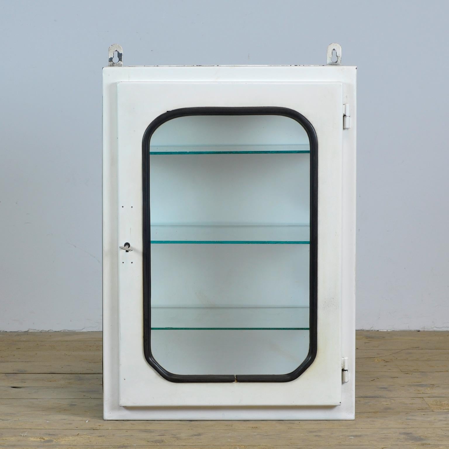 This medical cabinet was designed in the 1970s and produced circa 1975 in hungary. It was used in a hospital in budapest. It is made of iron and glass. The glass is held by a black rubber strip. The cabinet comes with three adjustable glass shelves.