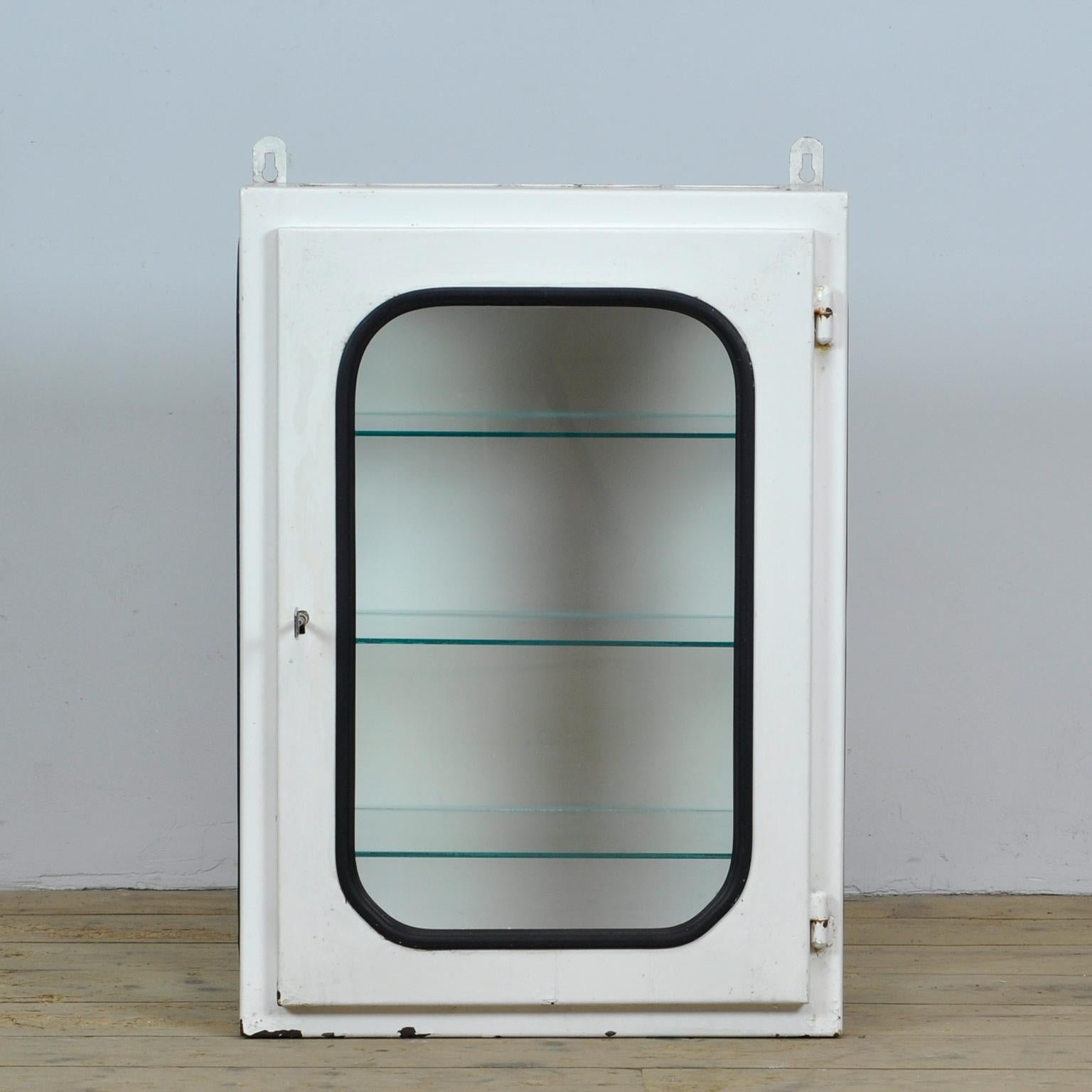 This medical cabinet (wall unit) was designed in the 1970s and produced circa 1975 in hungary. It was used in a hospital in budapest. It is made of iron and glass. The glass is held by a black rubber strip. The cabinet comes with three adjustable