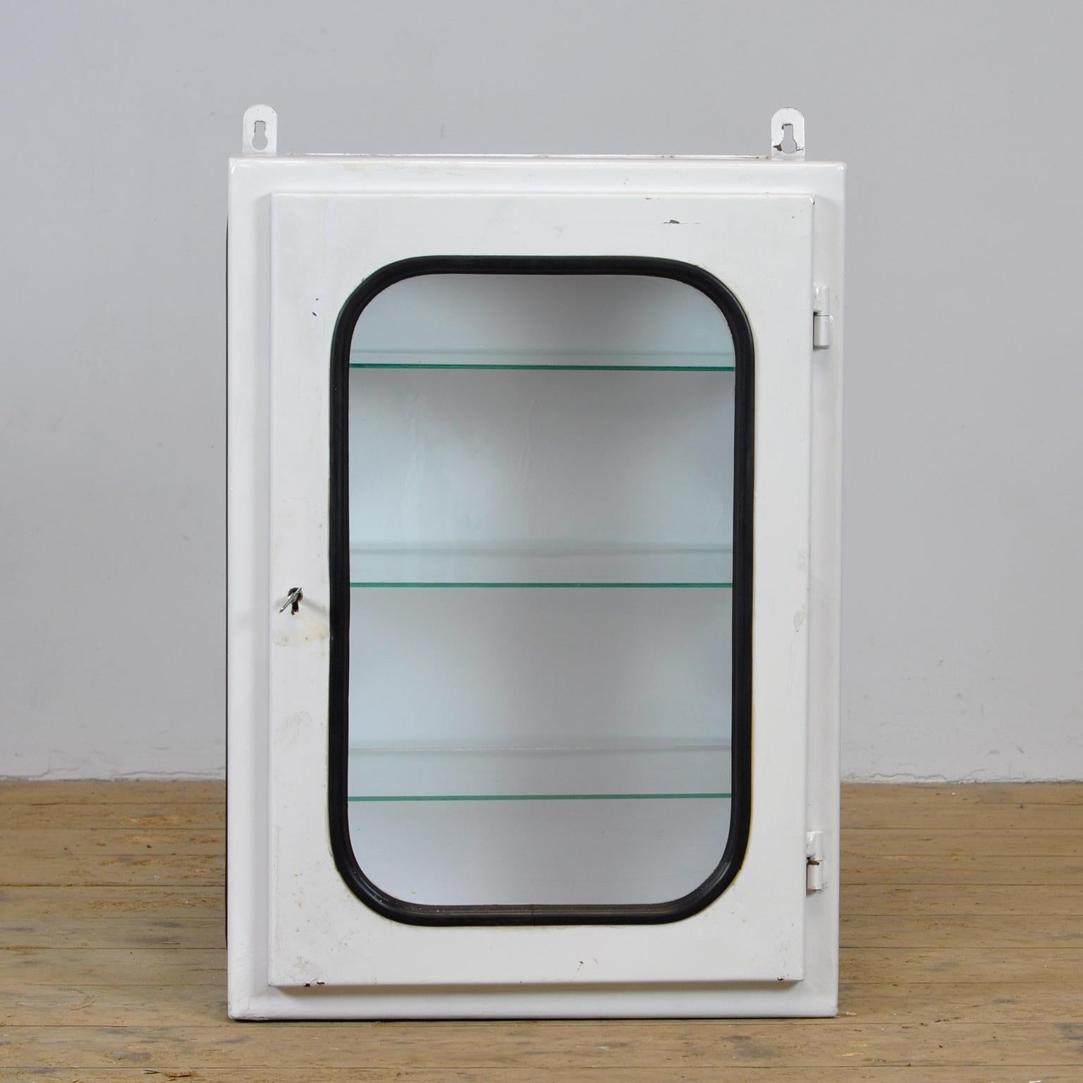 This medical cabinet was designed in the 1970s and produced circa 1975 in hungary. It was used in a hospital in budapest. It is made of iron and glass. The glass is held by a black rubber strip. The cabinet comes with three adjustable glass shelves. 
