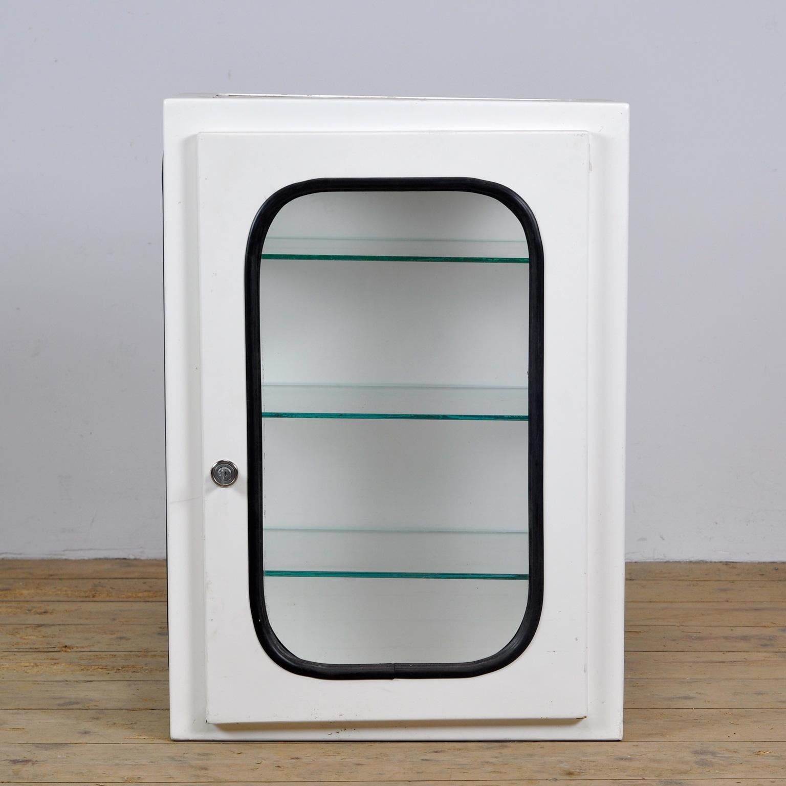This medical cabinet was designed in the 1970s and produced circa 1975 in hungary. It was used in a hospital in budapest. It is made of iron and glass. The glass is held by a black rubber strip. The cabinet comes with three adjustable glass shelves.