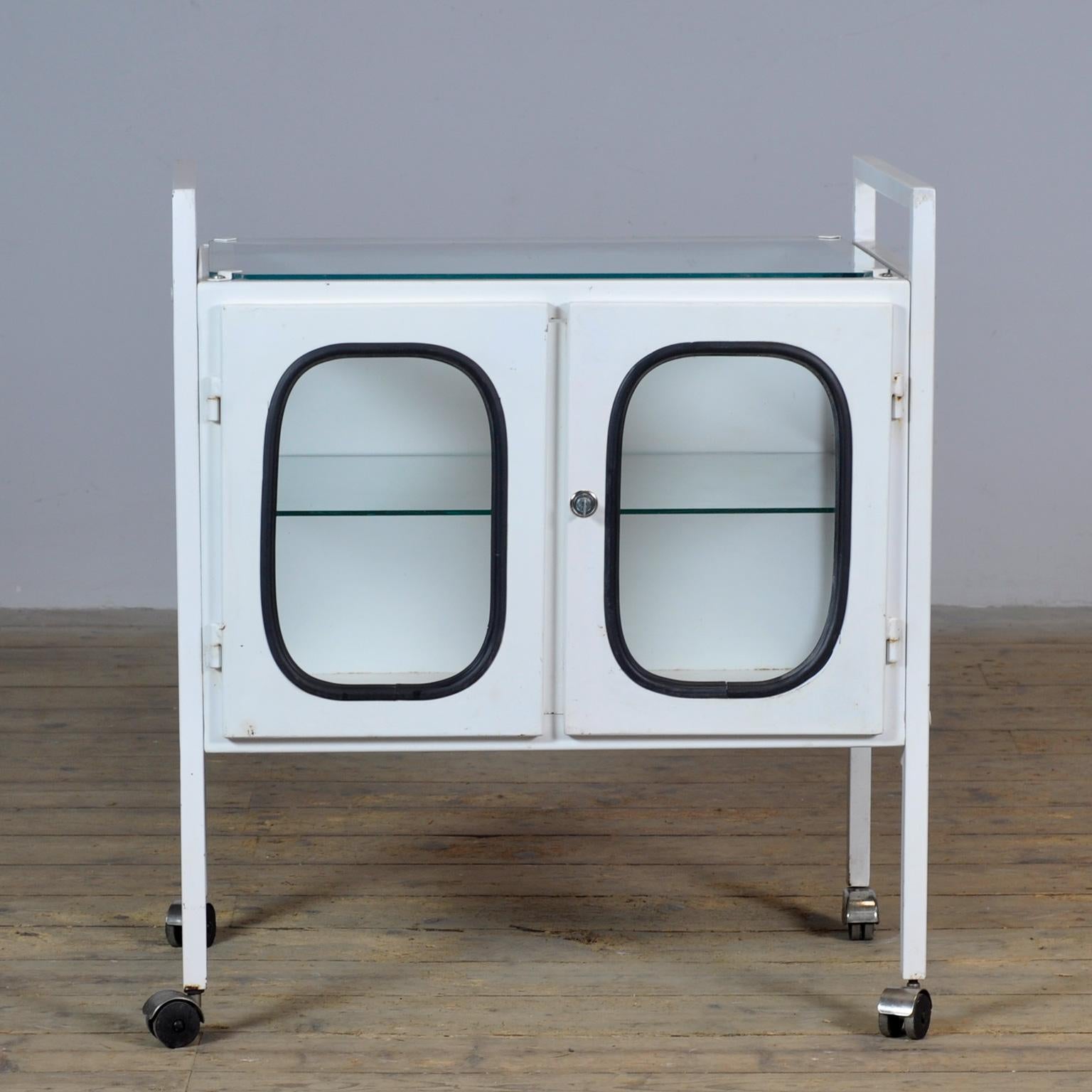 Chariot d'hôpital Vintage en bon état. Composé d'acier et de verre qui est serré dans l'acier par une bande de caoutchouc. Ce meuble date des années 70 et a été fabriqué en Hongrie.
La hauteur du plateau est de 83 cm.