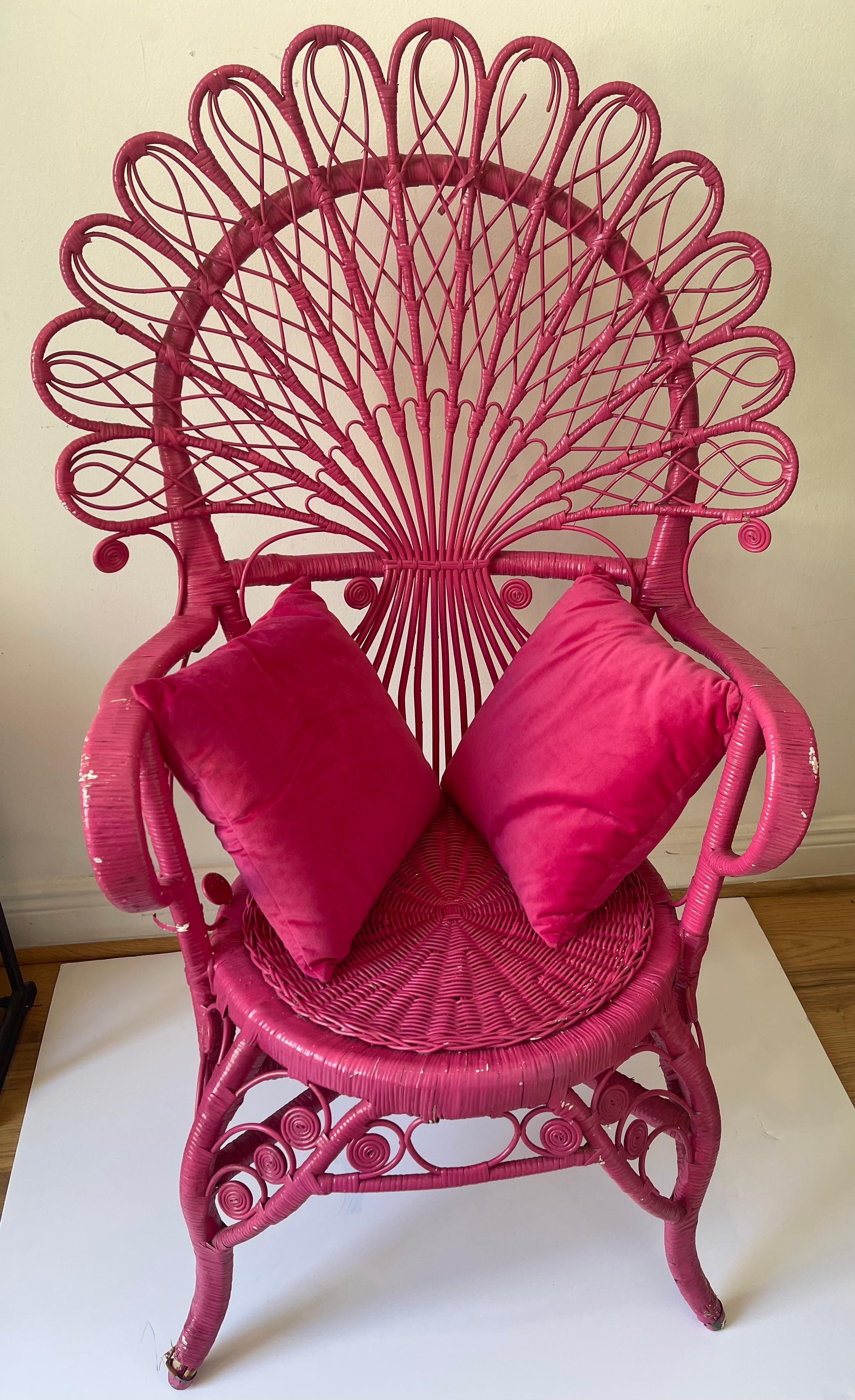 Vintage hot pink handmade wicker chair with pair of velvet pillows.