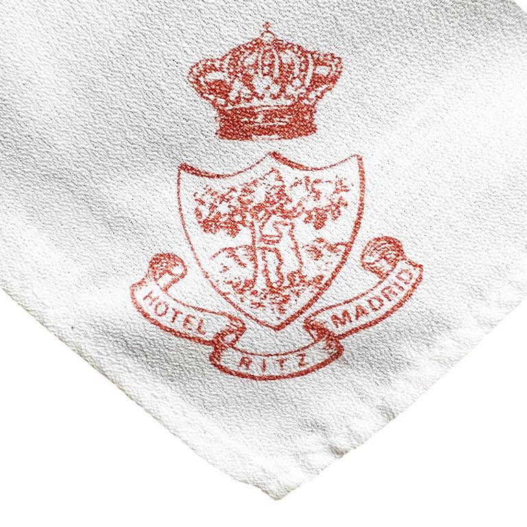 A rare set of four linen table napkins from the iconic Hotel Ritz Madrid. This vintage set includes four table napkins in white, each stamped with the Hotel Ritz Madrid in red at the corner along with the hotel's signature crest. Add this set to an