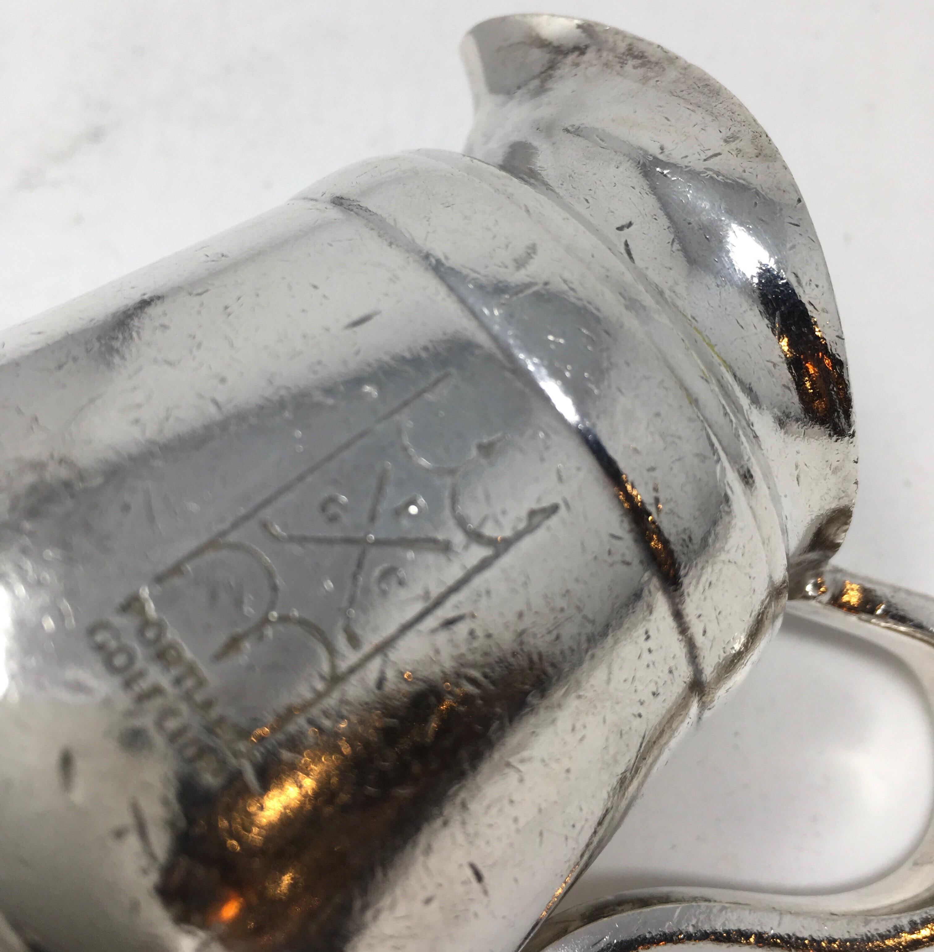 This vintage hotel silverplate creamer is fully hallmarked on the underside Reed & Barton, Silver Soldered, 2800 4oz, Portland Golf Club. Bearing the mark P G C, Portland Golf Club on the side, this creamer has been well used and the imperfections