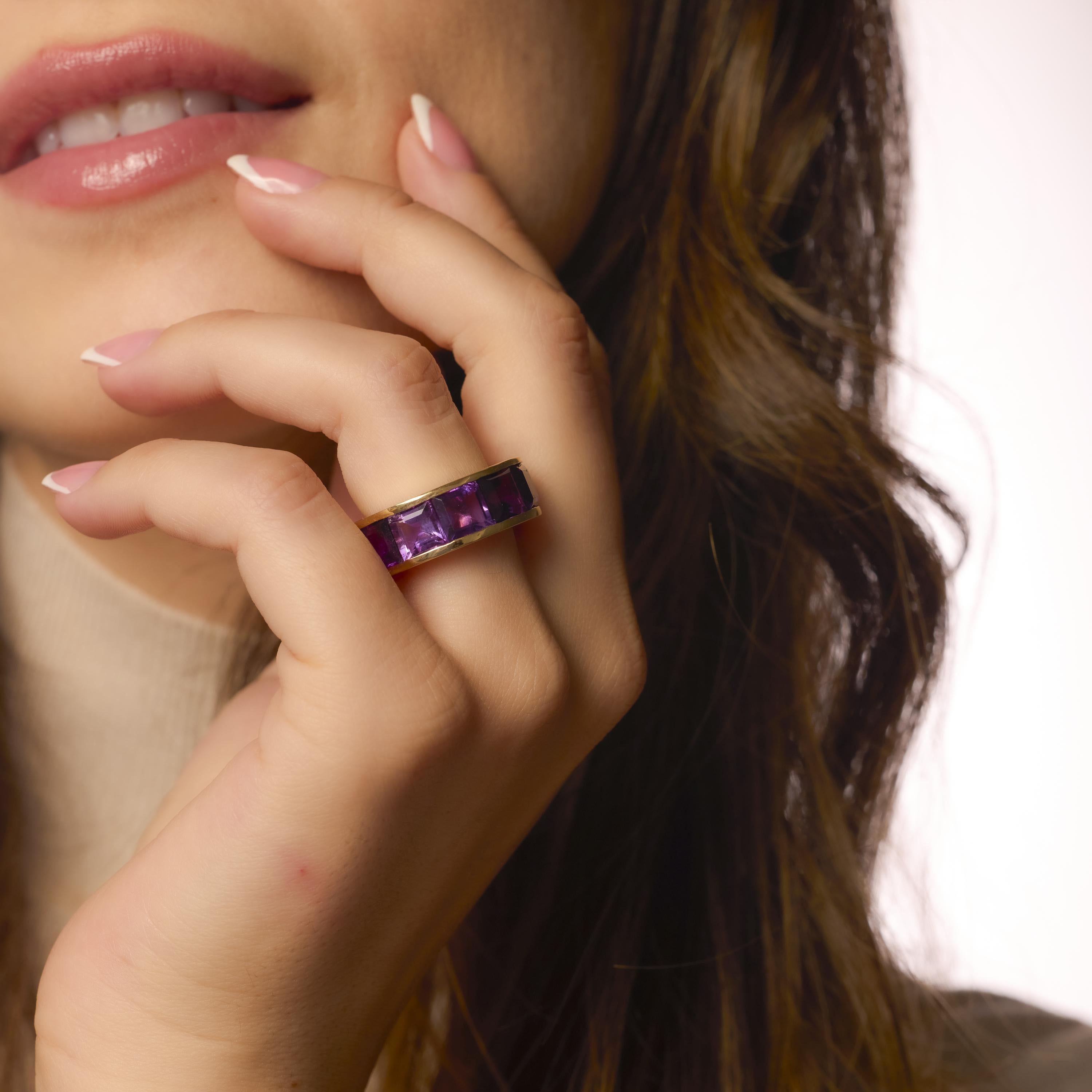 This bold vintage Hubert ring showcases vivid baguette cut amethysts set in gleaming 14k yellow gold, making a vibrant and sculptural statement.