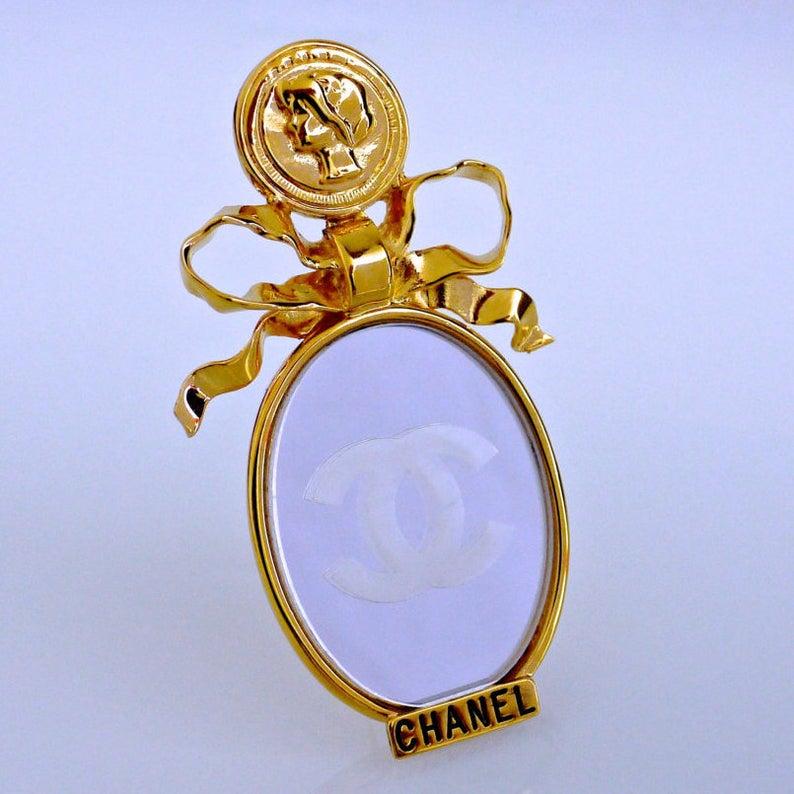 Vintage Huge CHANEL Mademoiselle Mirror Brooch

Measurements:
Height: 3 6/8 inches
Width: 2 1/8 inches

This Vintage CHANEL Mademoiselle Mirror Brooch is very rare and beautiful! It is a highly coveted Red Carpet Piece. A must have.

Features:
-