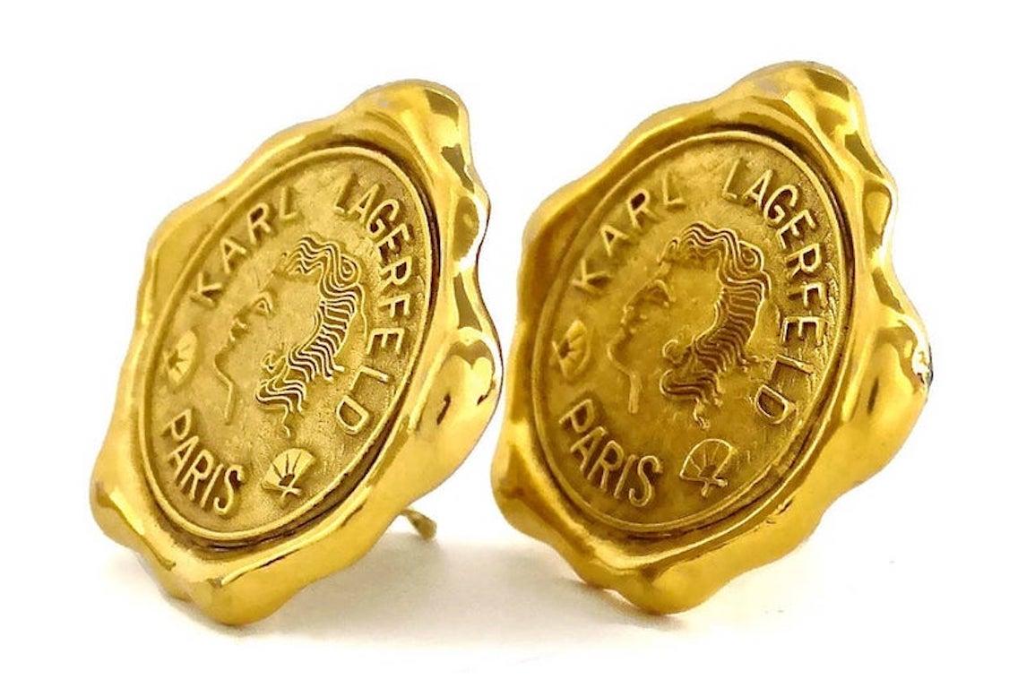 Vintage Huge KARL LAGERFELD Profile Wax Seal Logo Earrings

Measurements:
Height: 1.69 inches (4.3 cm)
Width: 1.77 inches (4.5 cm)
Weight: 26 grams

Features:
- 100% Authentic KARL LAGERFELD.
- Lagerfeld wax seal profile earrings.
- Embossed KARL