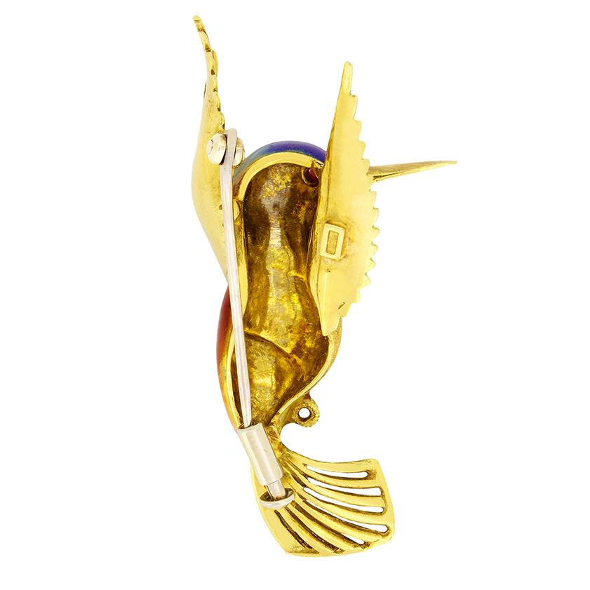 This whimsical brooch takes on the likeness of a Hummingbird. Crafted from 18 carat yellow gold in the 1960s the intricately designed piece features enamel work across the head and body to bring the vibrancy of a hummingbird to life. A glittering