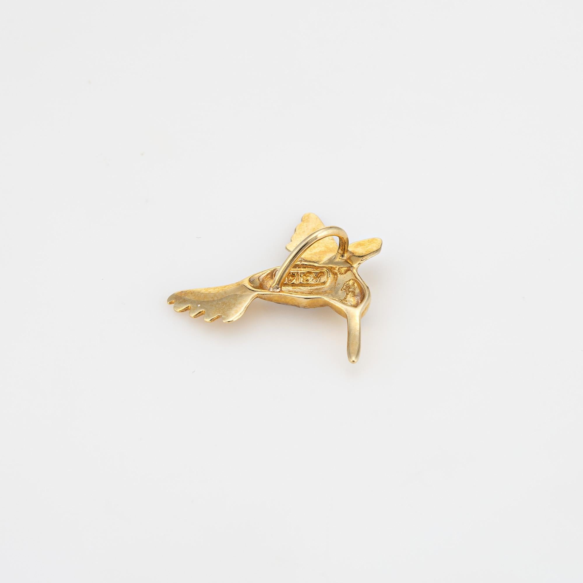 Finely detailed vintage Hummingbird pendant crafted in 14k yellow gold.  

Small in scale, the hummingbird is one of nature's most graceful creatures. Crafted with intricate attention to detail, the pendant depicts the hummingbird in mid-flight, its