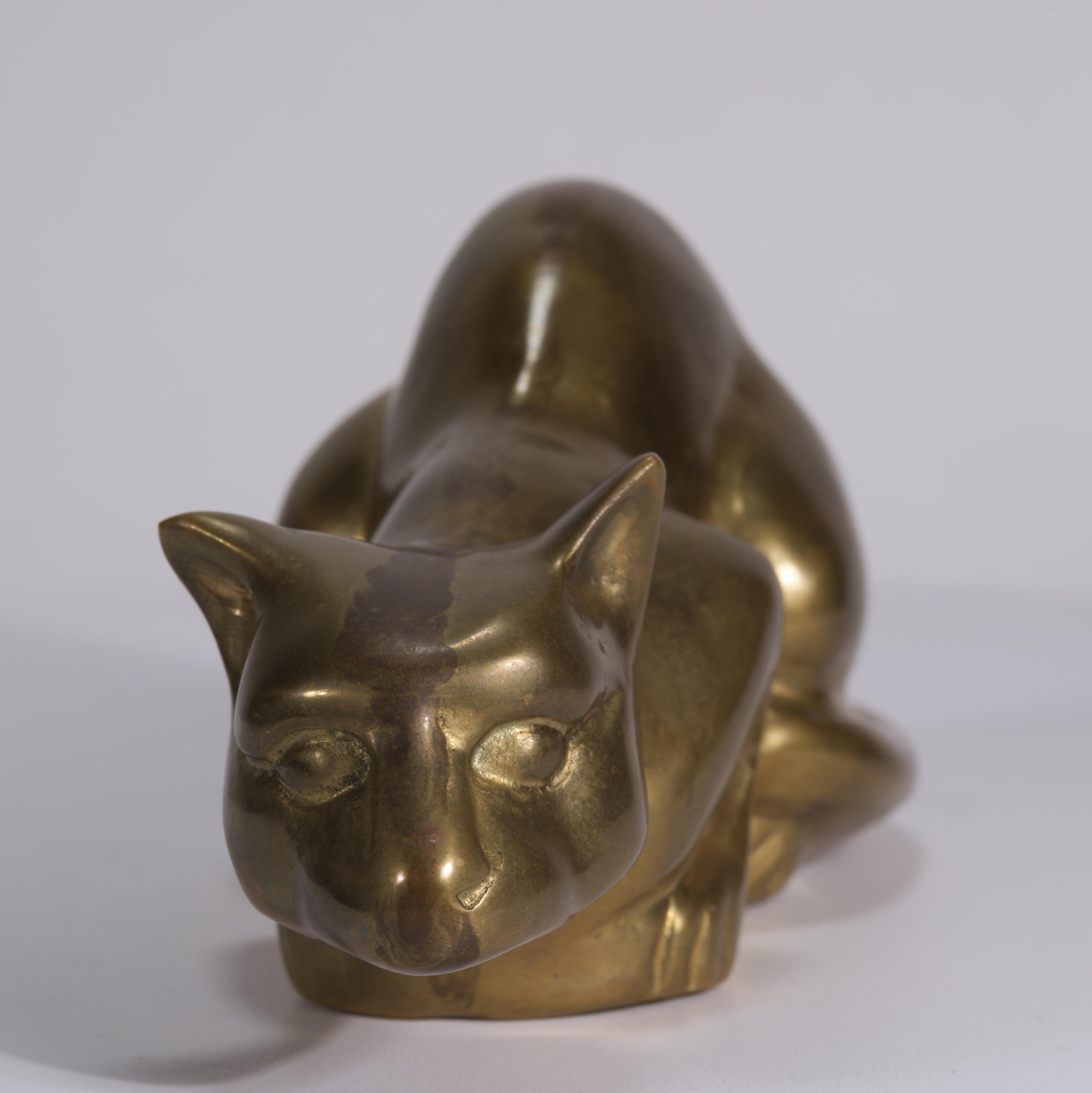 Vintage brass figurine depicts a cat in a crouching position, hunting and ready to pounce on its prey. The cat is sculpted in Modernist style with significant Art Deco influence.

The heavy, substantial piece can be used either as decor piece or an