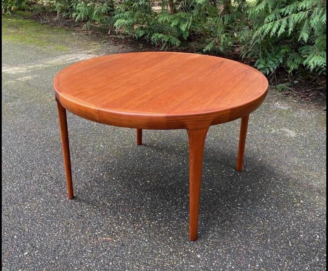 Offering an original vintage IB Kofod Larsen for Faarup Mobelfabrik Danish Mid Century Modern MCM teak oval dining table, with two original leaves, ca. late 1950s - 1960s. Can transition from a circular form (without leaves) to an oval (with one or