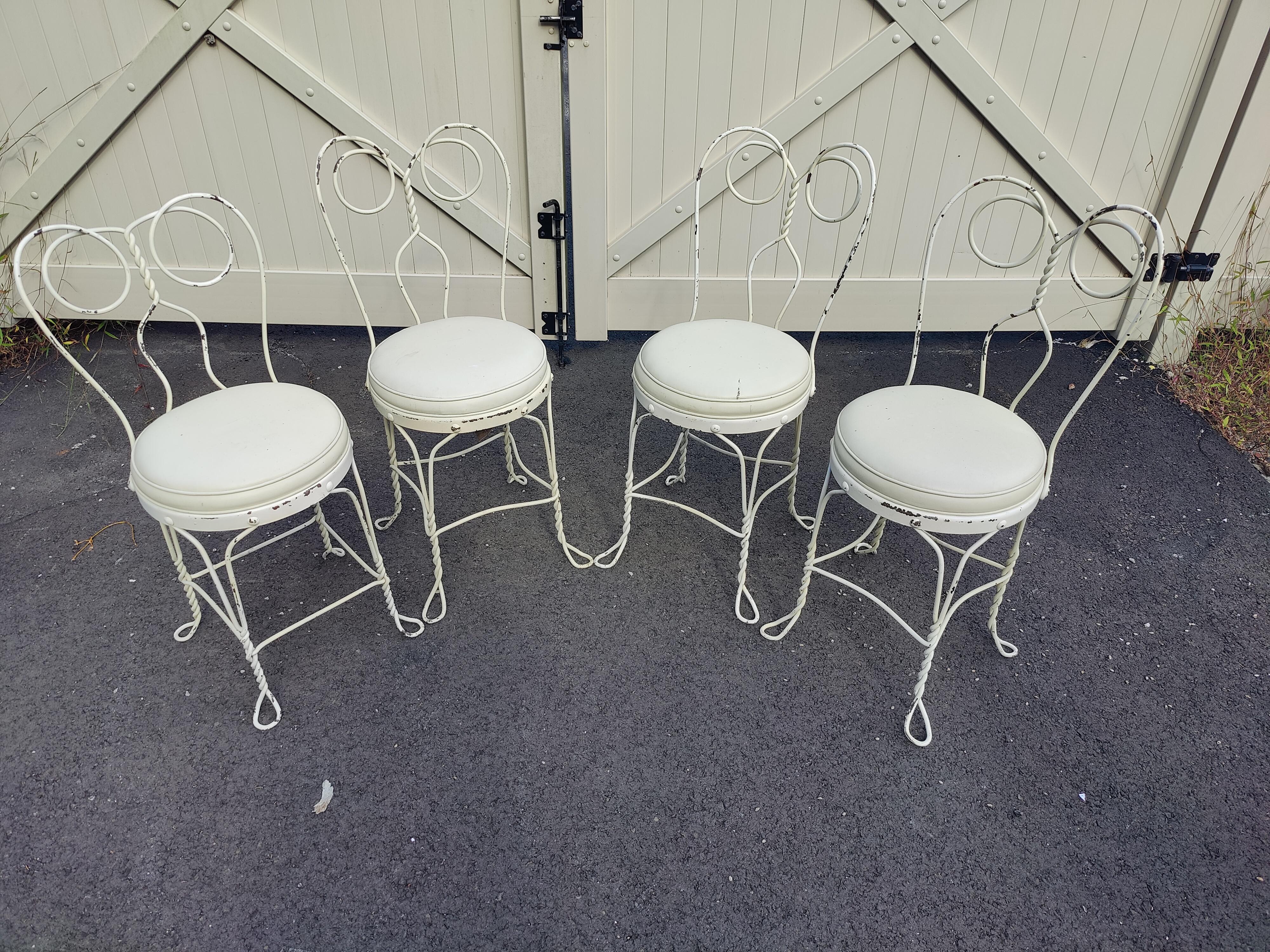 Set of ( 4 ) vintage wrought iron ice cream chairs. Featuring twisted metal legs, back and white upholstered seats.

(Please confirm item location - NY or NJ - with dealer).