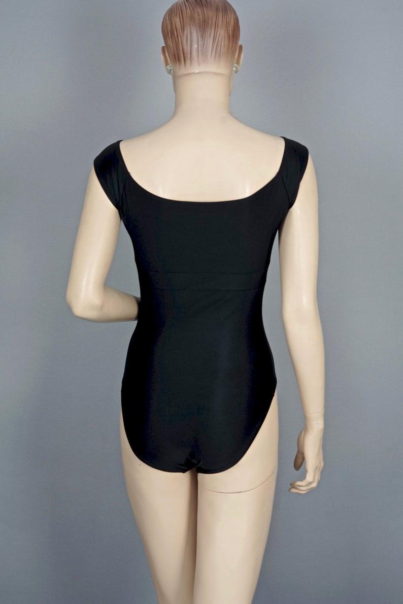 Vintage Iconic CHANEL Camellia Flower Bow Bathing Suit Swimsuit Bodysuit

Will fit size 38, the mannequin is size 36.

As seen on Helena Christensen.

Features:
- 100% Authentic CHANEL.
- Black one piece swimsuit with scooped neckline.
- Iconic