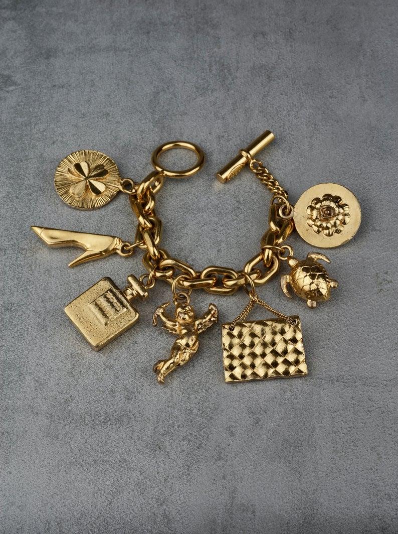 Vintage Iconic CHANEL Lucky Charm Bracelet

Measurements:
Height: 2.36 inches (6 cm)
Wearable Length: 7.87 inches (20 cm)

Features:
- 100% Authentic CHANEL.
- Chunky chain with Chanel's 7 lucky charms: Turtle, Chanel Perfume Bottle, Angel, Chanel