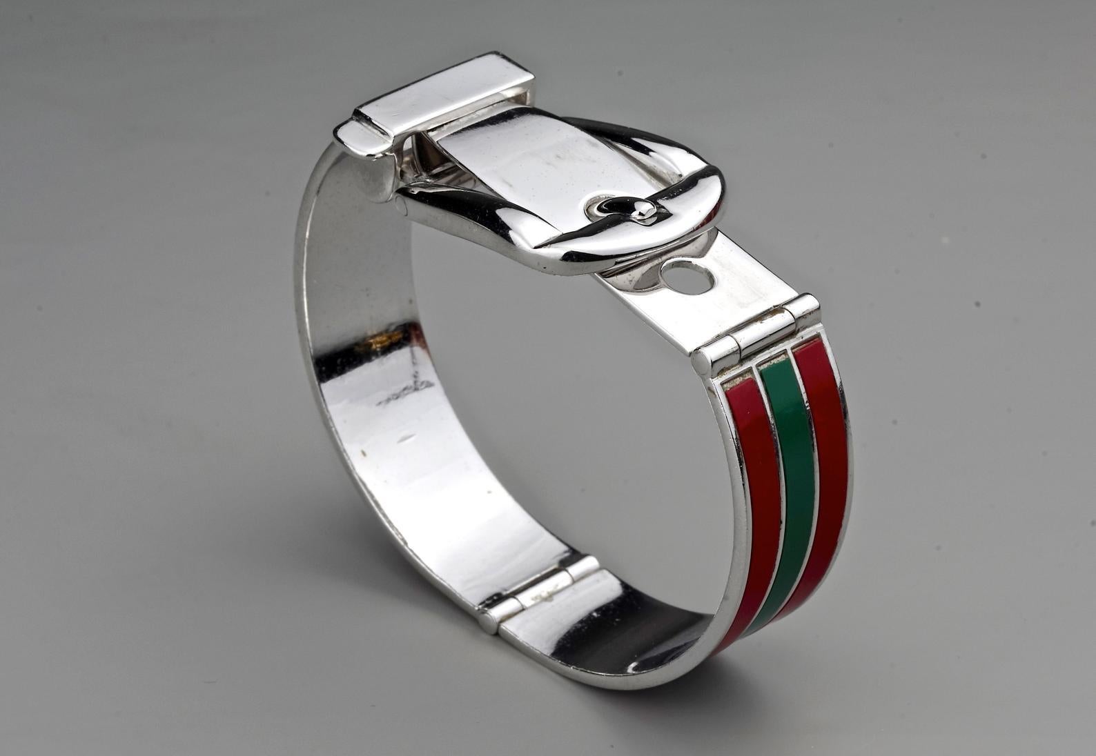 Vintage Iconic GUCCI Enamel Buckle Cuff Bracelet

Measurements:
Height: 1 inch (2.5 cm)
Wearable Length: 6.42 inches to 6.85 inches (16.3 cm to 17.4 cm)

Features:
- 100% Authentic GUCCI.
- Iconic GUCCI green and red enamel strips.
- Adjustable