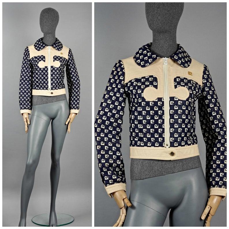 Vintage Iconic PIERRE CARDIN Monogram Vinyl Mod Jacket

Measurements taken laid flat:
Shoulder: 14.96 inches (38 cm)
Sleeves: 22.44 inches (57 cm)
Bust: 17.13 inches (43.5 cm)
Waist: 15.74 inches (40 cm)
Length: 17.91 inches (45.5 cm)

Features:
-