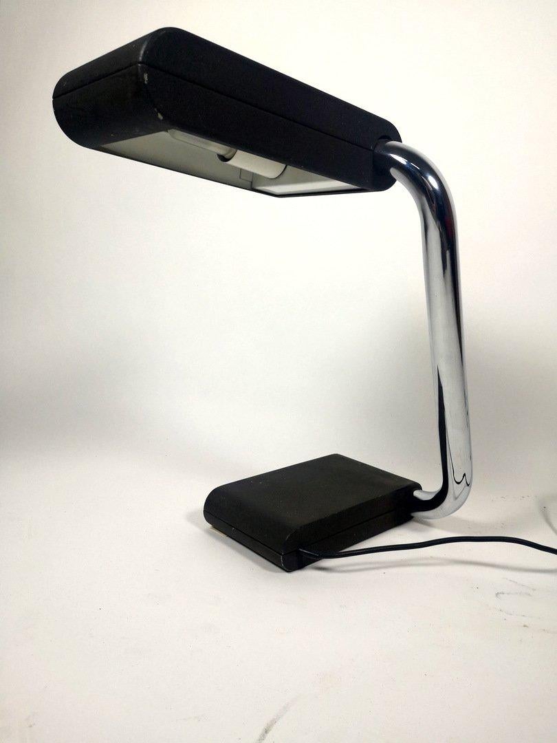 This vintage table lamp features an iconic design form Hillebrand. The adjustable table lamp has a wide chrome stand and black painted top and base. Stamped with the original paper stamp. This piece has an attribution mark such as a manufacturer’s