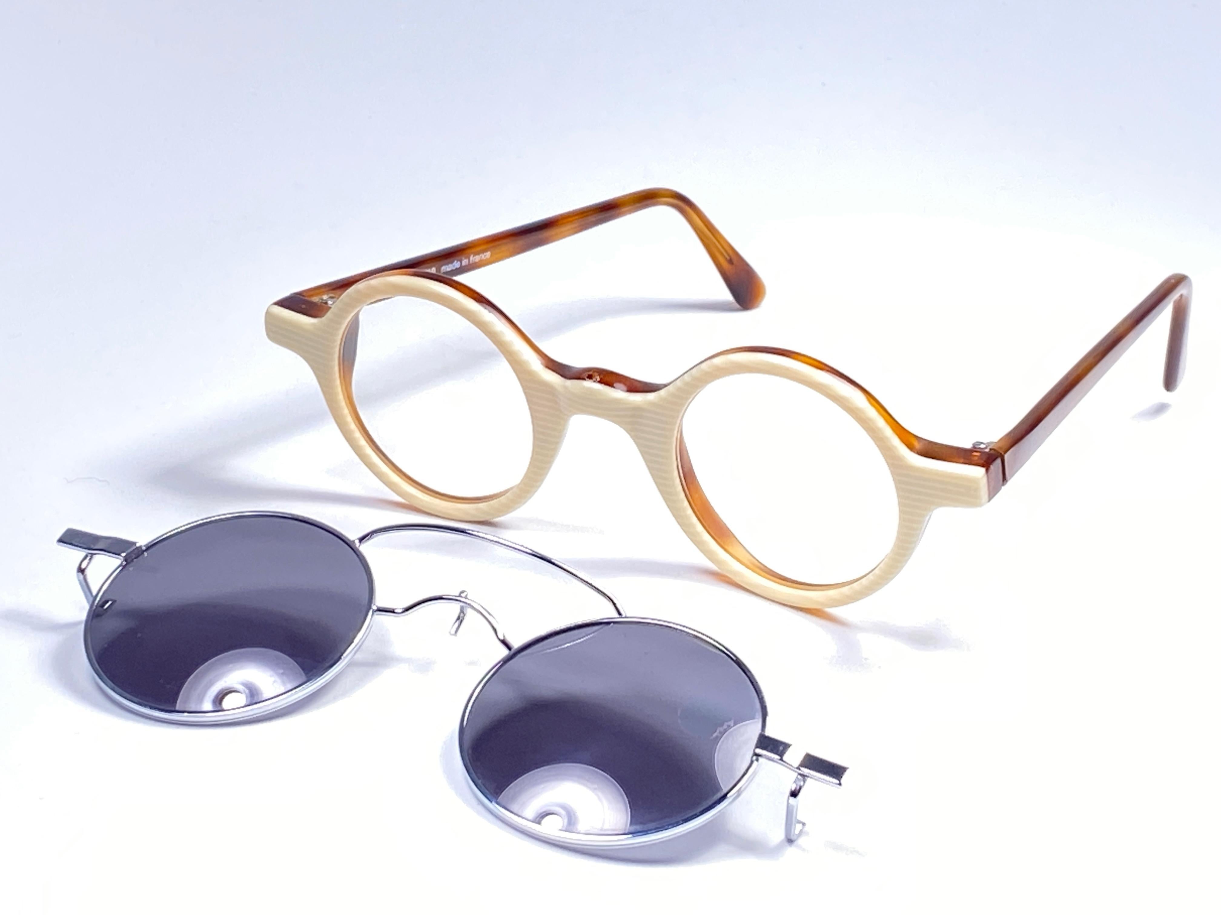 

IDC by Jean Francois REY small round tortoise, clear lenses to adapt RX prescription ones featuring a sunglasses clip on lenses.

This pair could show minor sign of wear due to storage. 
Made in France.