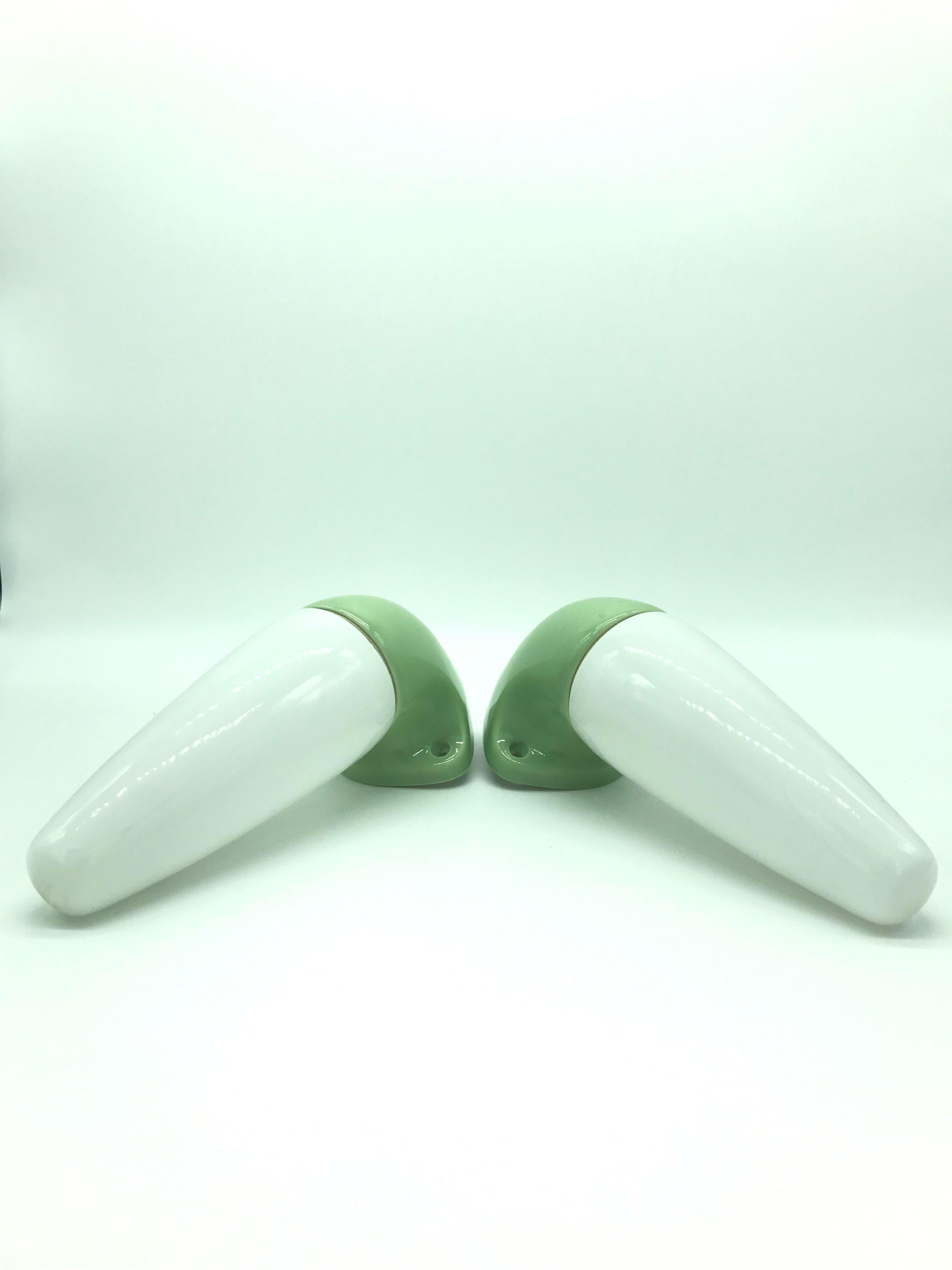 A pair of vintage Ifö of Sweden ceramic bathroom lamps model 6035 from the 1960s in lime green.
Designed by Sigvard Bernadotte. 
Opaline glass shades. 
Ceramic bulb holders for an E15 bulb
Lamps can be used as up or down lights.
In great