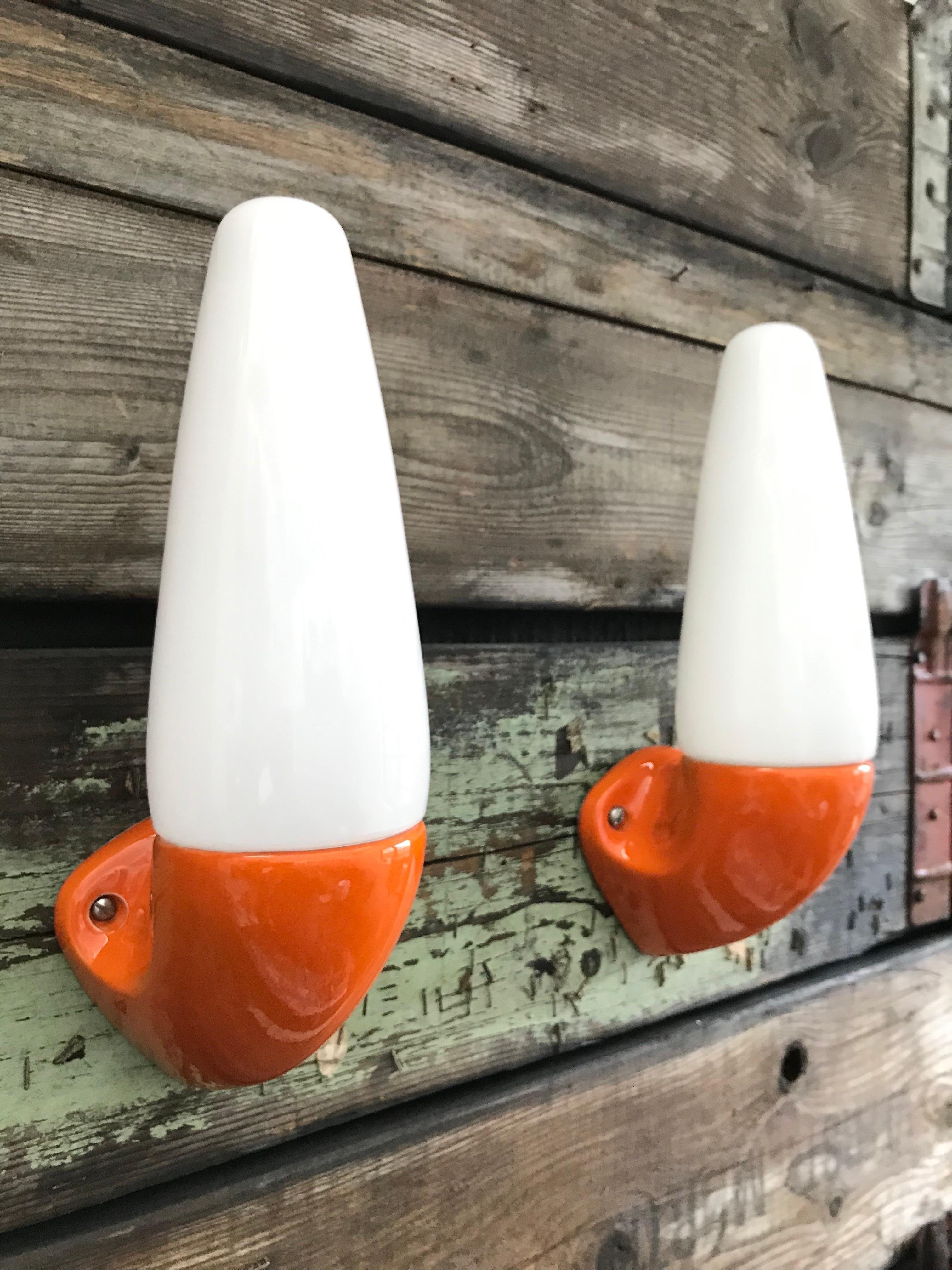 A pair of vintage orange Ifö of Sweden ceramic bathroom lamps model 6035 from the 1960s.
Designed by Sigvard Bernadotte. 
Opaline glass shades. 
Ceramic bulb holders for an E14 bulb
Lamps can be used as up or down lights.
In great condition and