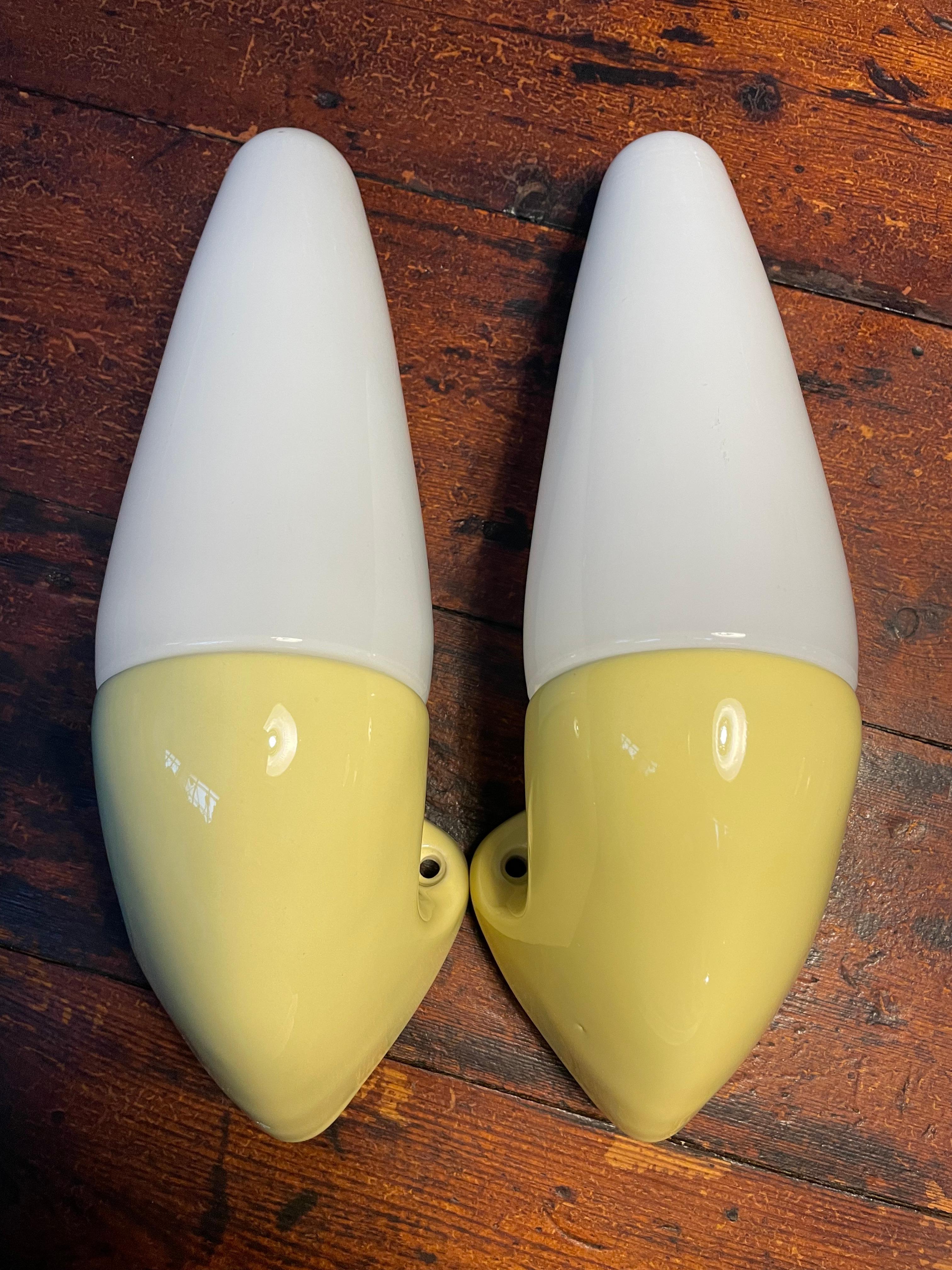 Vintage Ifö of Sweden ceramic bathroom lamps from the 1960s in yellow color. 
Model 6035. 
Designed by Sigvard Bernadotte. 
Opaline glass shades. 
Ceramic bulb holders for an E14 bulb
Lamps can be used as up or down lights.
In great condition and