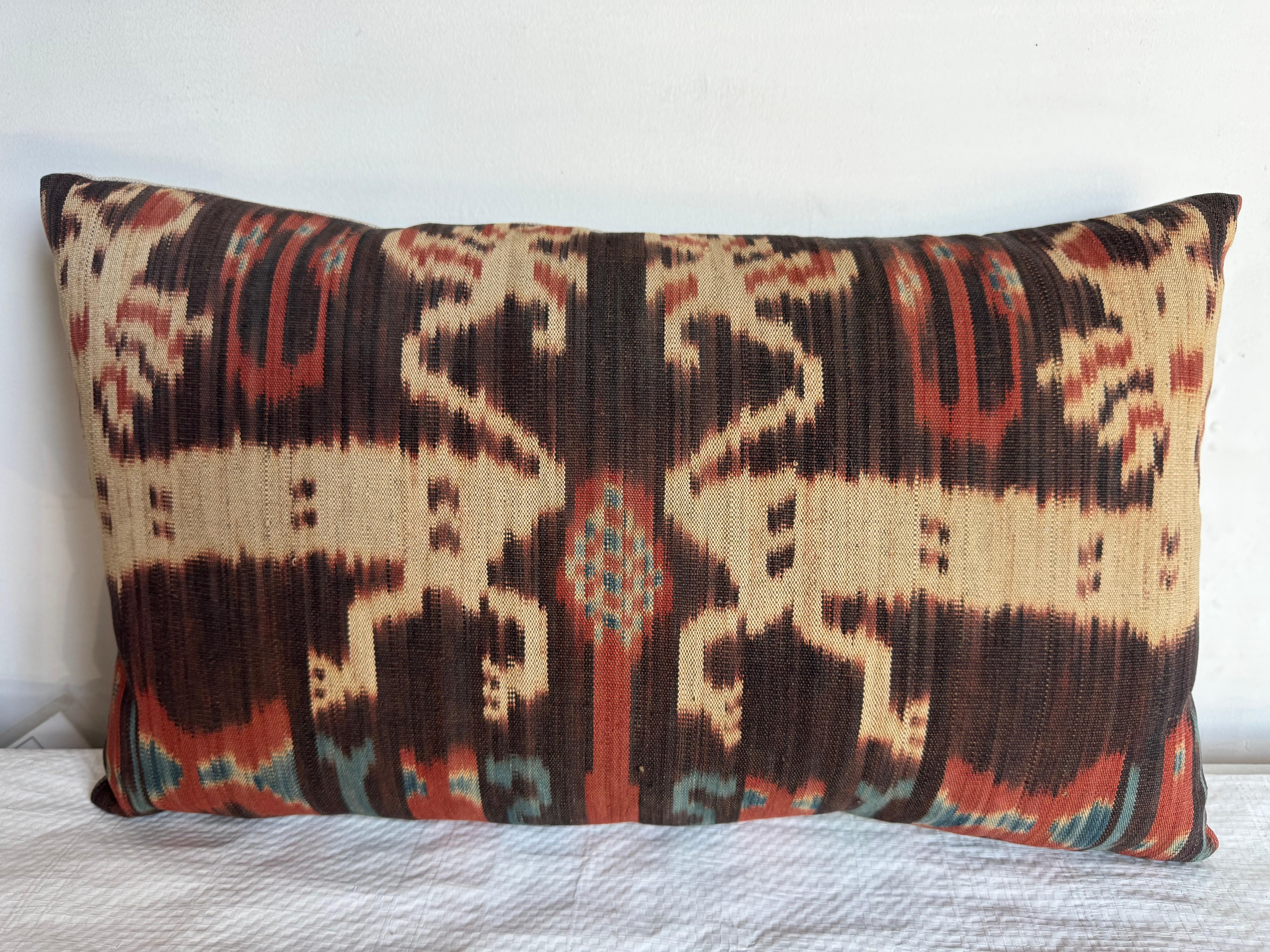 Ce vibrant coussin 1850 Ikat présente des motifs abstraits audacieux dans des tons chauds et terreux. Le motif traditionnel, rendu dans des bruns doux et rouille, ajoute une touche dynamique et énergique à n'importe quel espace.

Mesurant 19