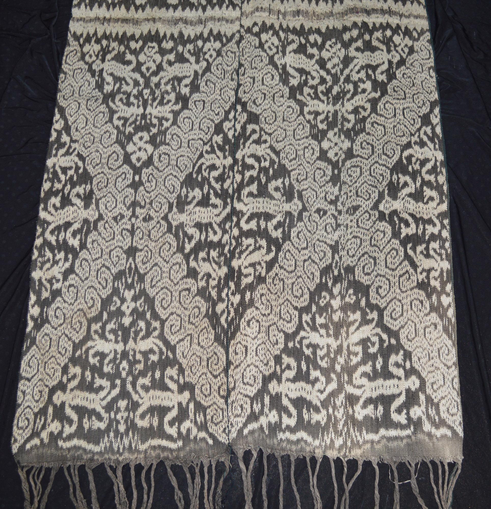 A Vintage woven Ikat cloth made using hand spun natural dyed cotton yarn on the island of Timor in Indonesia.

Comprising of 2 panels sewn together to form a larger cloth a technique often used in older ikat textiles from the region.
Featuring a