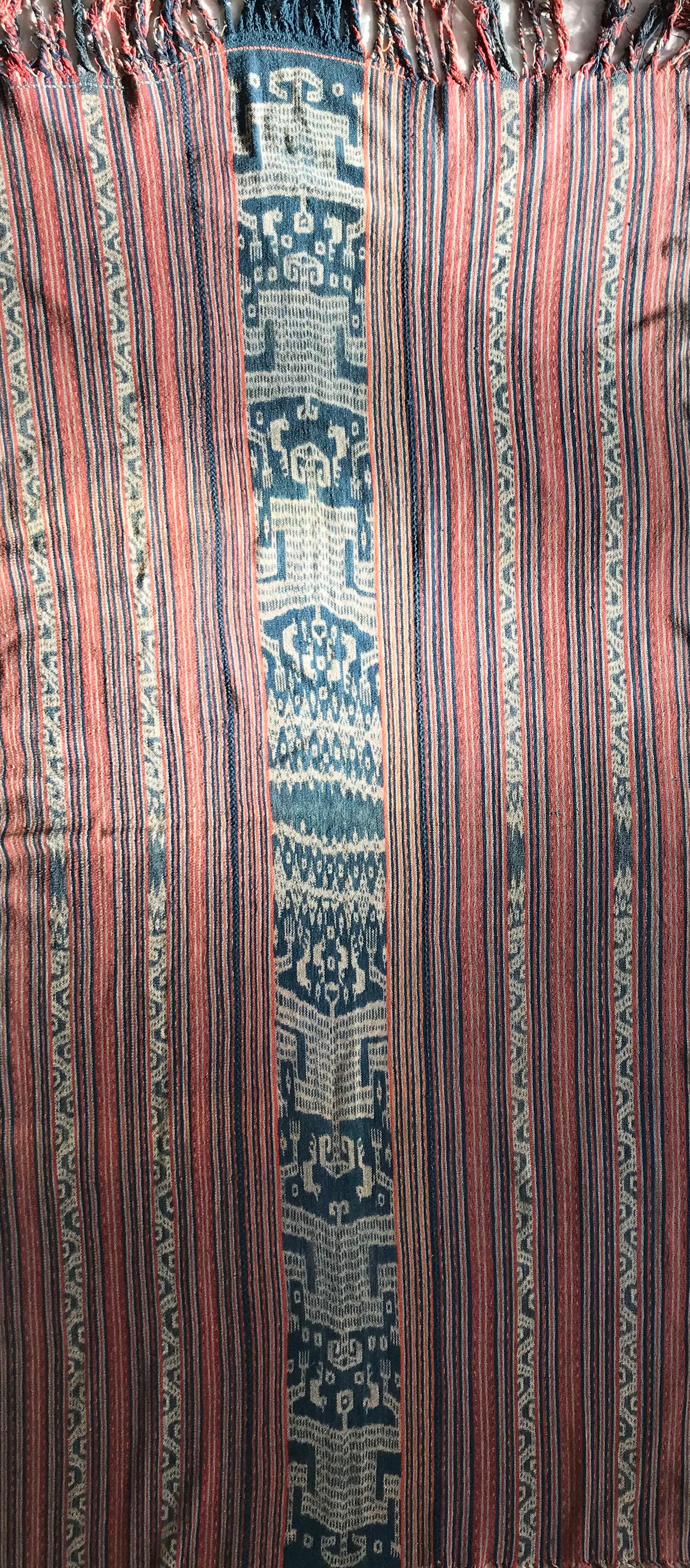 A Vintage woven Ikat cloth made using hand spun natural dyed cotton yarn on the island of Timor in Indonesia.

Comprising of 2 panels sewn together to form a larger cloth a technique often used in older ikat textiles from the region.
Featuring a