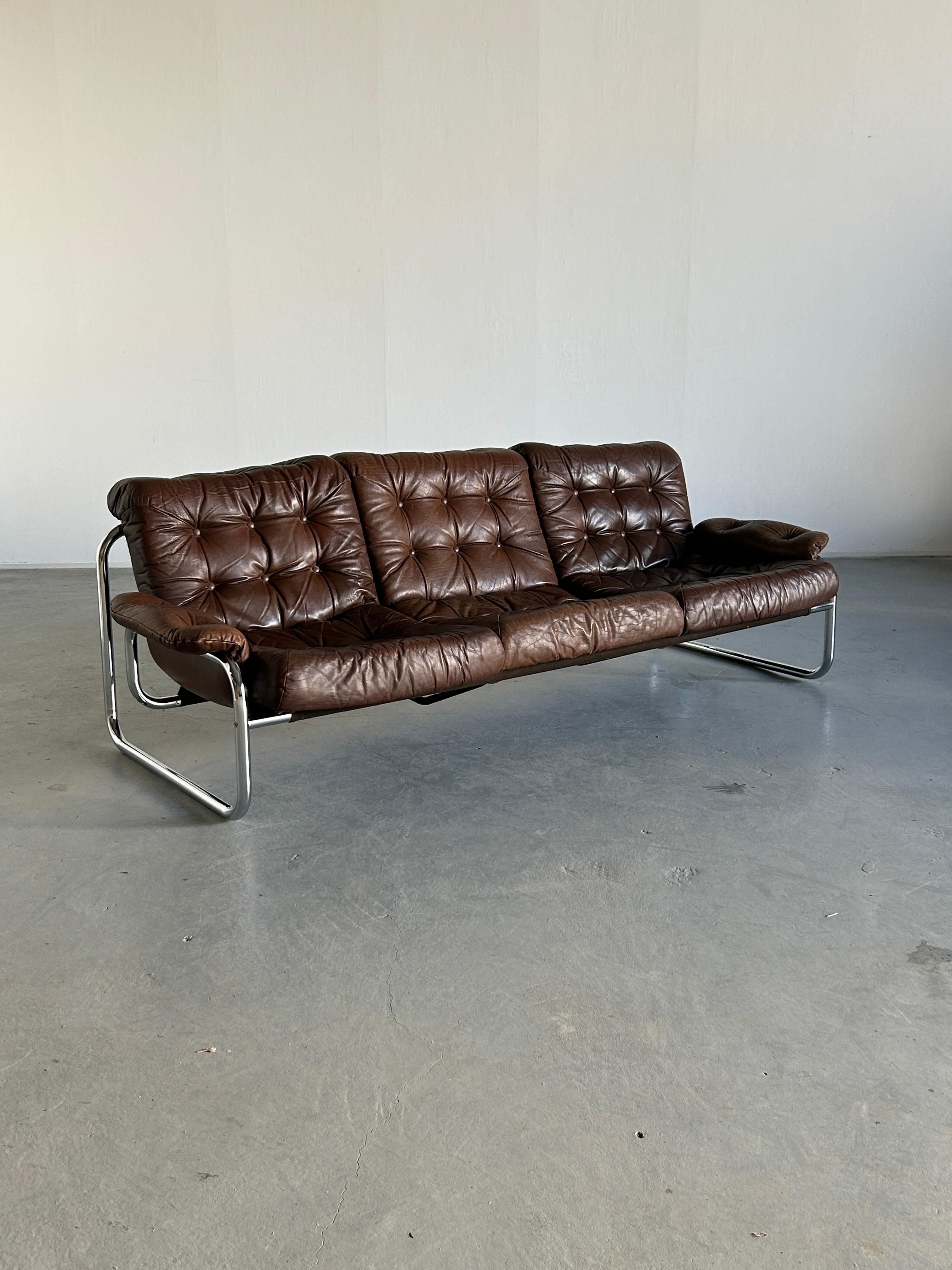 Swedish modern chromed tubolar steel and original brown leather tufted three-seater sofa by Johann Bertil Häggström for Ikea, 1970s.

This piece is one of the most successful IKEA products from the 1970s, and a very rare find.
Sourced from a Swedish