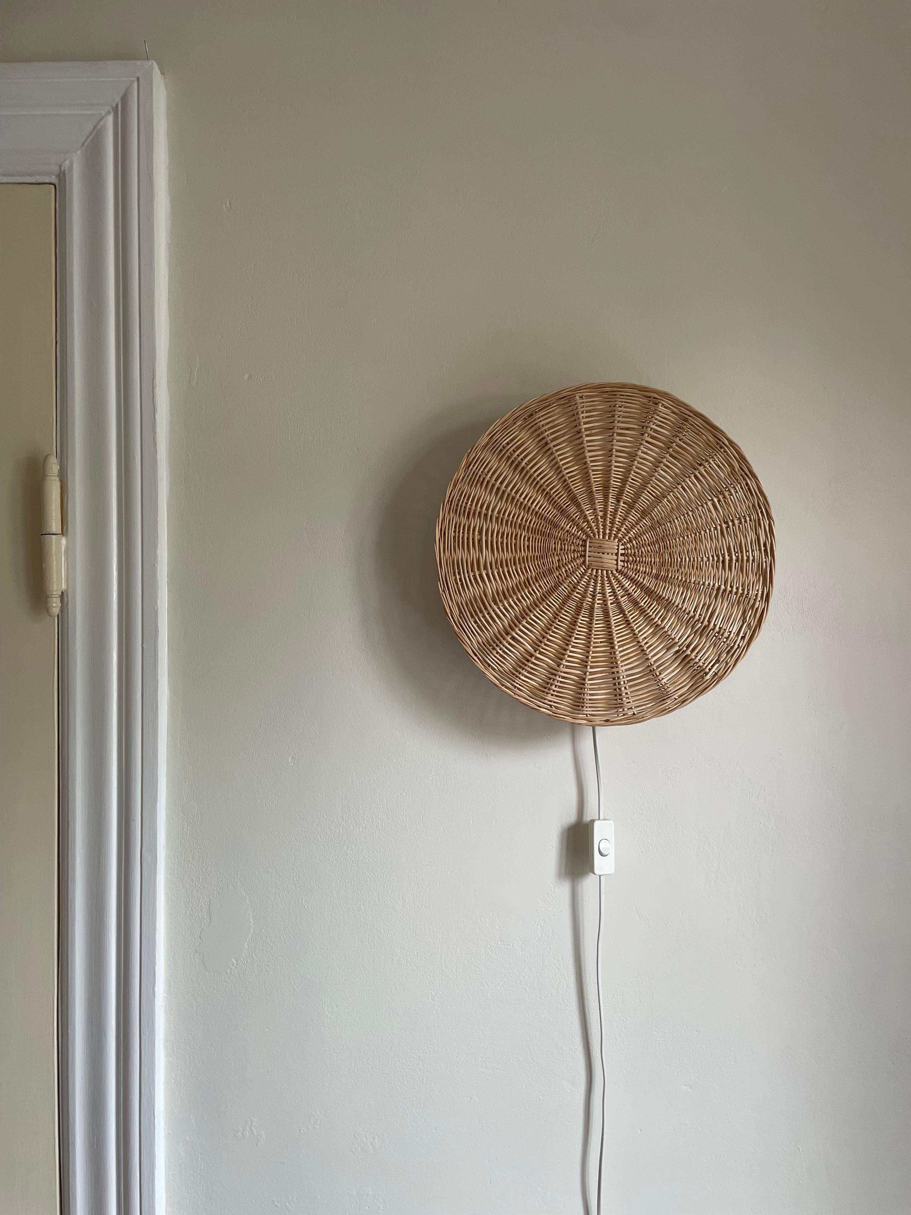 Round hand-braided Nordic modern bamboo wall light manufactured by IKEA in the 1980s. White lacquered metal mount and original wiring with switch and plug-in. Label on mount. Great vintage condition. 
Sweden, 1980s.