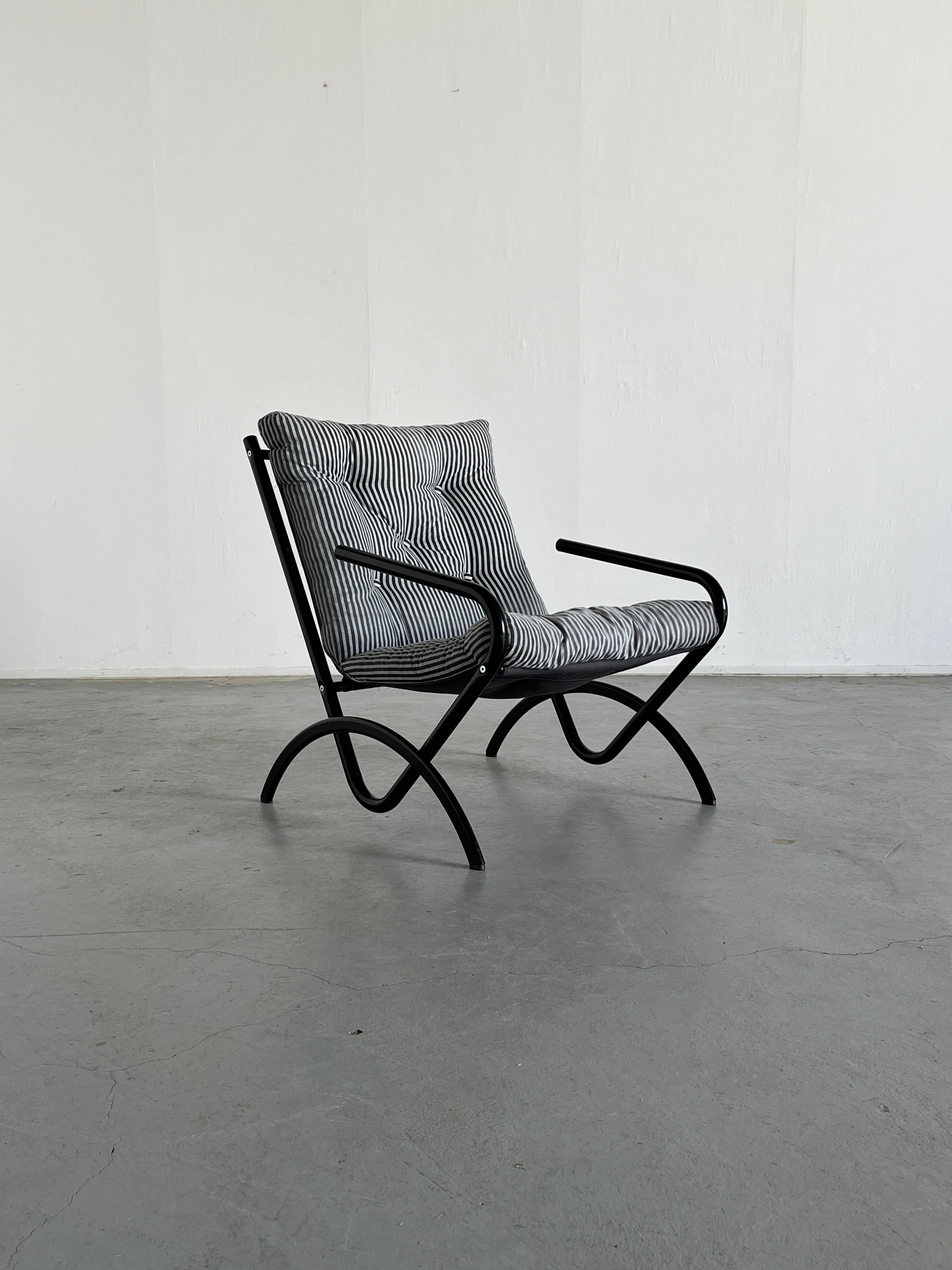Un sillón postmoderno de diseño Memphis, estilo Ikea vintage. Estructura metálica, espuma triturada y tela a rayas blancas y negras.
Llamativo, minimalista... ¡y cómodo!

En general, se encuentra en buen estado, con los signos propios de la edad.