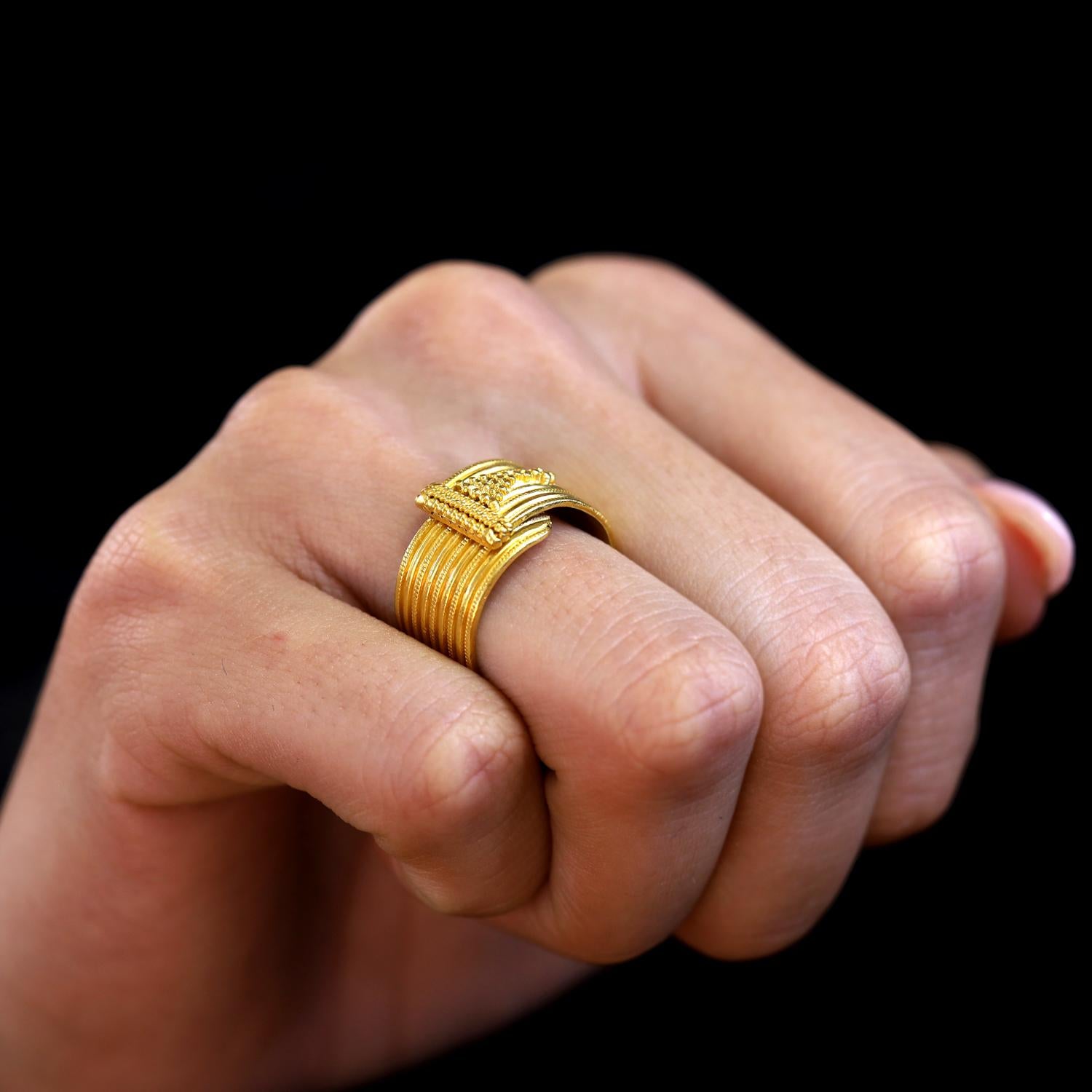 A bold and rich 22k yellow gold wide band ring from renowned Grecian jeweler Lalaounis. The Etruscan design, reminiscent of ancient times, was hand created displaying granulation, braiding and linear features in this bold 9mm cigar band. The long