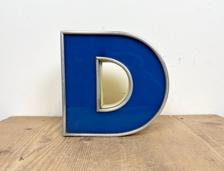 This vintage industrial illuminated letter N was made in Italy during the 1970s and comes from an old advertising banner. It features a yellow metal body and a blue plexiglass cover. It is equipped with a LED strip. The letter can be used as a table